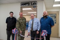From left: Scott Ziv, a mechanical engineer in Carderock’s Additive Manufacturing Branch; Capt. Todd Hutchison, Commanding Officer; Paul Young, head of the Fabrication and Technical Support Division; and Ryan Franke, a technician in Carderock’s Subtractive and Additive Manufacturing Branch, cut the ribbon during the grand opening of Carderock’s new Advanced Manufacturing Prototyping (AMP) Lab on June 23, 2022. (U.S. Navy photo by Devin Pisner)