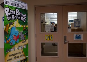 A poster about the summer reading program is displayed outside the library, June 30, 2022, on Holloman Air Force Base, New Mexico. The summer reading program rewarded children and other base residents with prizes for time spent reading. (U.S. Air Force by Airman 1st Class Corinna Diaz)