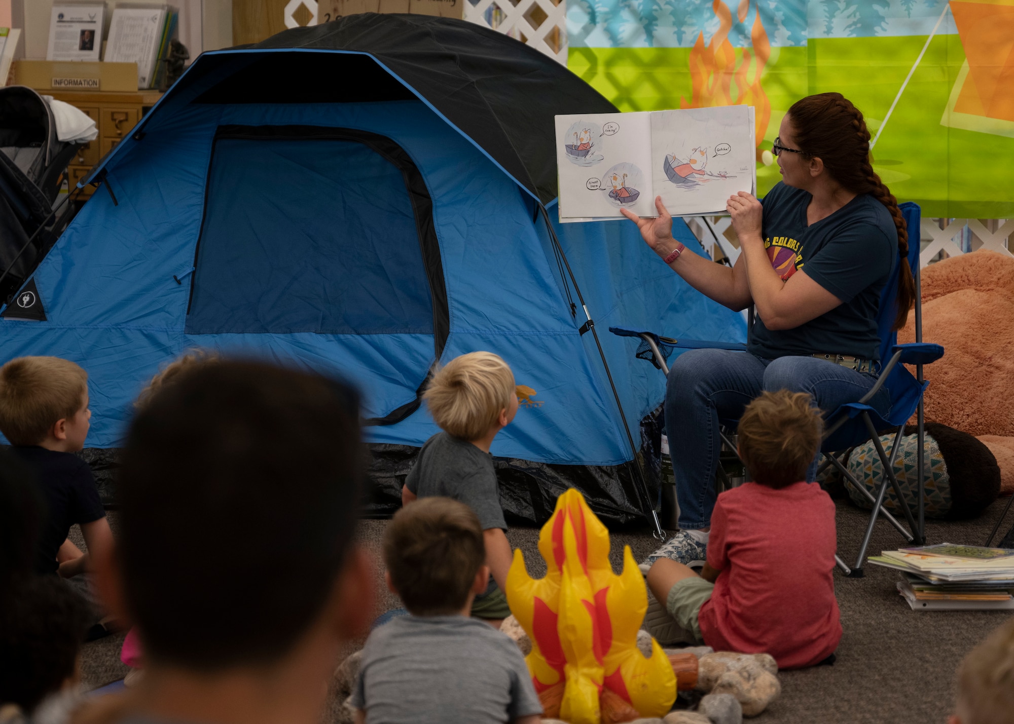Lisa Collins, 49th Force Support Squadron library director, reads a story to children at the library, June 29, 2022, on Holloman Air Force Base, New Mexico. The story time counts toward the children’s reading time for the summer reading program. (U.S. Air Force photo by Airman 1st Class Corinna Diaz)