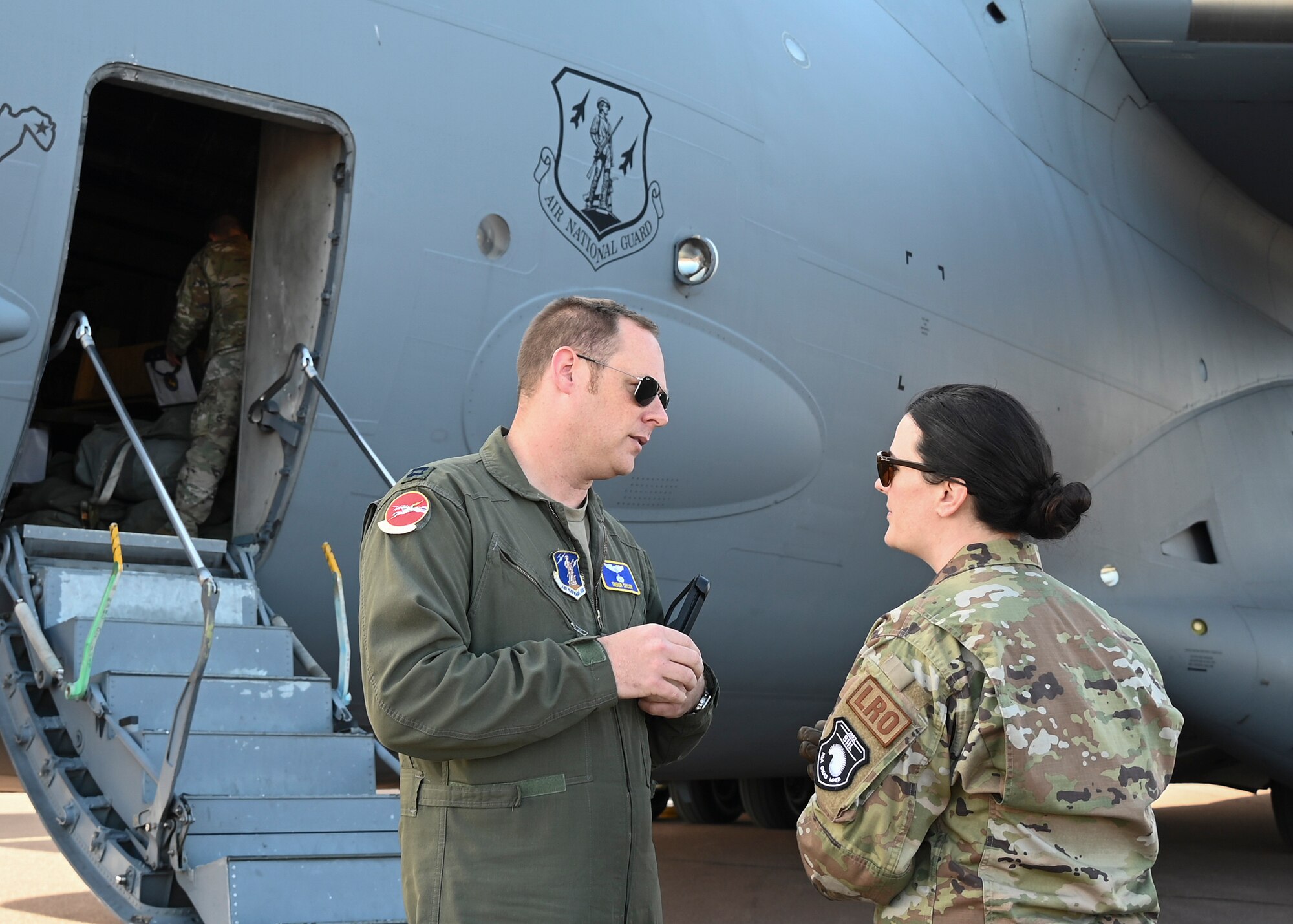 U.S. Air Force Capt. Trebor Taylor, a C-17 pilot assigned to the 167th Airlift Wing, West Virginia Air National Guard, speaks with U.S. Air Force Lt. Joanna Voss, an installation deployment officer assigned to the 175th Logistics Readiness Squadron, Maryland Air National Guard, during the DEFENDER-Europe 22 exercise, May 23, 2022, in Kuressaare, Estonia.