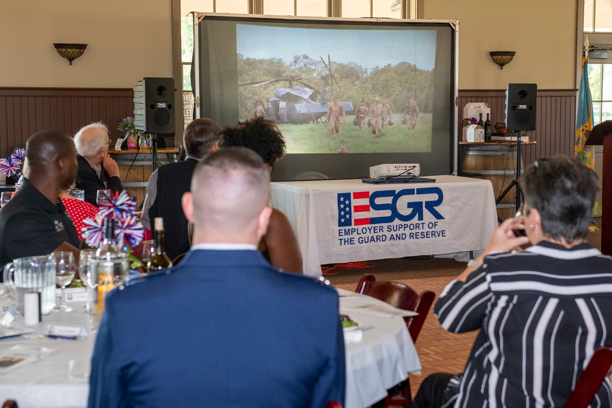 Attendees of the Employer Support of the Guard and Reserve 50th Anniversary Dinner watch a video at the Harvest Ridge Winery in Marydel, Delaware, June 29, 2022. The video showcased various responsibilities of reservists and guardsmen and highlighted the ESGR’s efforts in ensuring both employer and employee meet all needs during time of service. The ESGR offers employer programs and provides insight into the duties of reservists and guardsmen across all branches of the military. (U.S. Air Force photo by Senior Airman Ruben Rios)