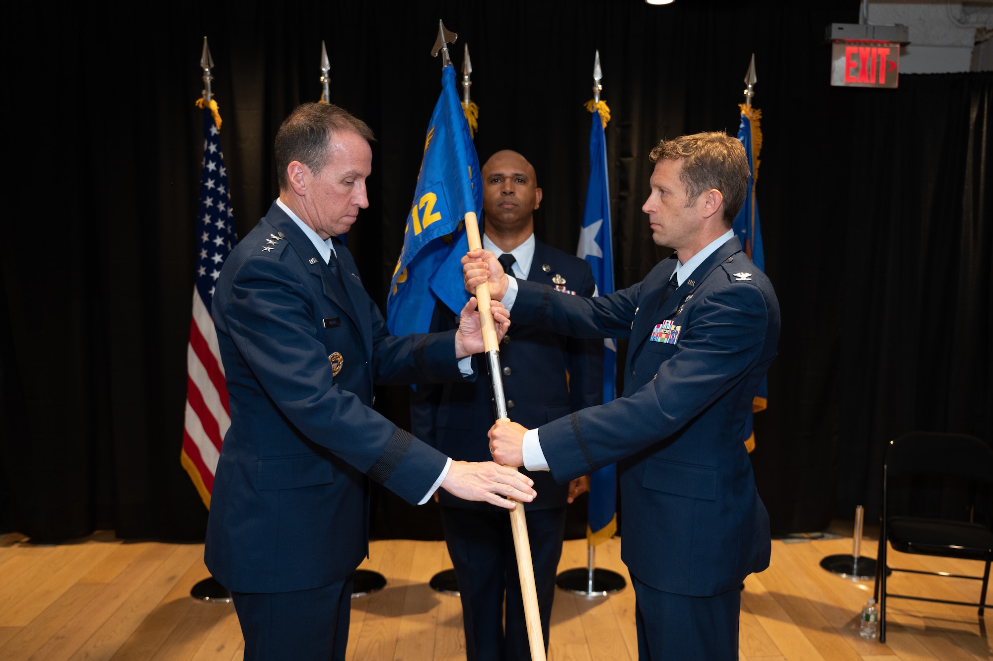 Lt. Gen. Shaun Q. Morris, Air Force Life Cycle Management Center commander, receives the AFLCMC’s Detachment 12 guidon from Col. Brian Beachkofski, Det. 12 commander, as Chief Master Sgt. Kevin D. Boles, Det. 12’s senior enlisted leader, stands at attention during a transition ceremony at the unit’s headquarters in Boston, June 27. Det. 12 transitioned from a detachment to a division of AFLCMC’s Digital Directorate. (U.S. Air Force photo by Jerry Saslav)