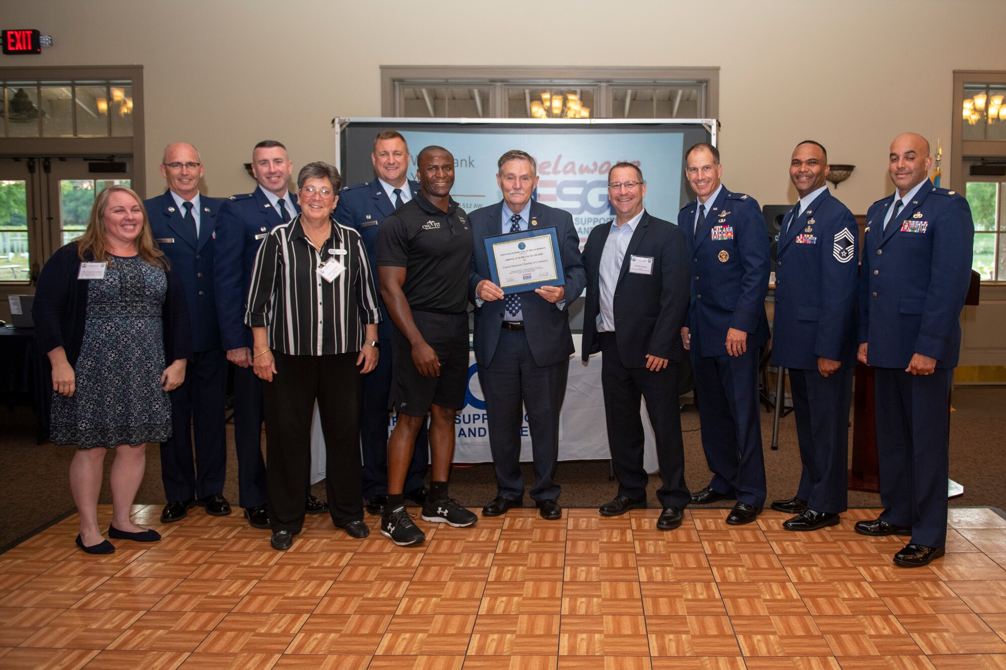 Members from the 512th and 436th Airlift Wings, both at Dover Air Force Base, Delaware, pose for a photo with members from the Central Delaware Chamber of Commerce and a representative from the Employer Support of the Guard and Reserve as they present an Above and Beyond Award to the CDCC at the Harvest Ridge Winery in Marydel, Delaware, June 29, 2022. The ESGR offers employer programs and provides insight into the duties of reservists and guardsmen across all branches of the military. (U.S. Air Force photo by Senior Airman Ruben Rios)