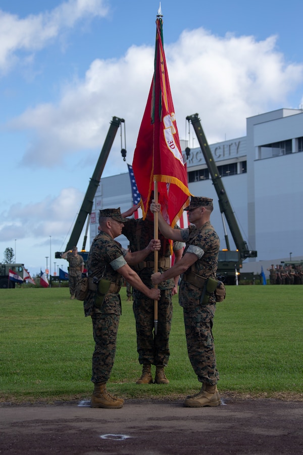 U.S. Marine Corps Brig. Gen. Brian Wolford, the outgoing commanding general for 3rd Marine Logistics Group, hands off the colors to Brig. Gen. Adam Chalkley, the oncoming commanding general for 3rd MLG, during a change of command ceremony on Camp Kinser, Okinawa, Japan, June 24, 2022. 3rd MLG, based out of Okinawa, Japan, is a forward deployed combat unit that serves as III Marine Expeditionary Force’s comprehensive logistics and combat service support backbone for operations throughout the Indo-Pacific area of responsibility. (U.S. Marine Corps photo by Lance Cpl. Hunter Barber)