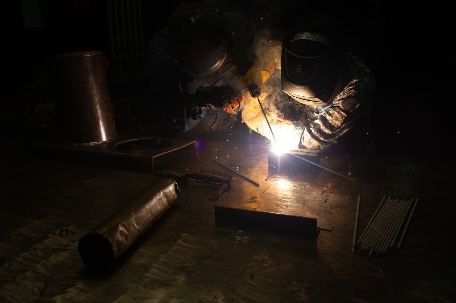 SINGAPORE (June 29, 2022) – U.S. Navy Hull Maintenance Technician 3rd Class Jaison Ford, assigned to the Emory S. Land-class submarine tender USS Frank Cable (AS 40), assists Republic of Singapore Navy Military Expert 7 Chow Yuk Hin, head of Submarine Systems Center, with welding procedure during a tour of the ship in Singapore, June 29, 2022. Frank Cable is currently on patrol conducting expeditionary maintenance and logistics in support of national security in the U.S. 7th Fleet area of operations. (U.S. Navy photo by Mass Communication Specialist 3rd Class Henry Liu)