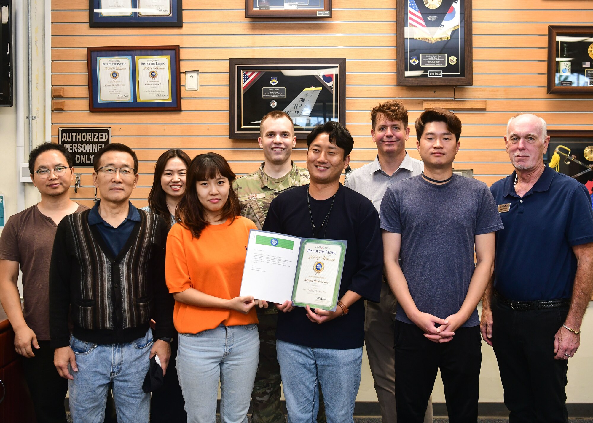 Military members and civilians pose for an award presentation.
