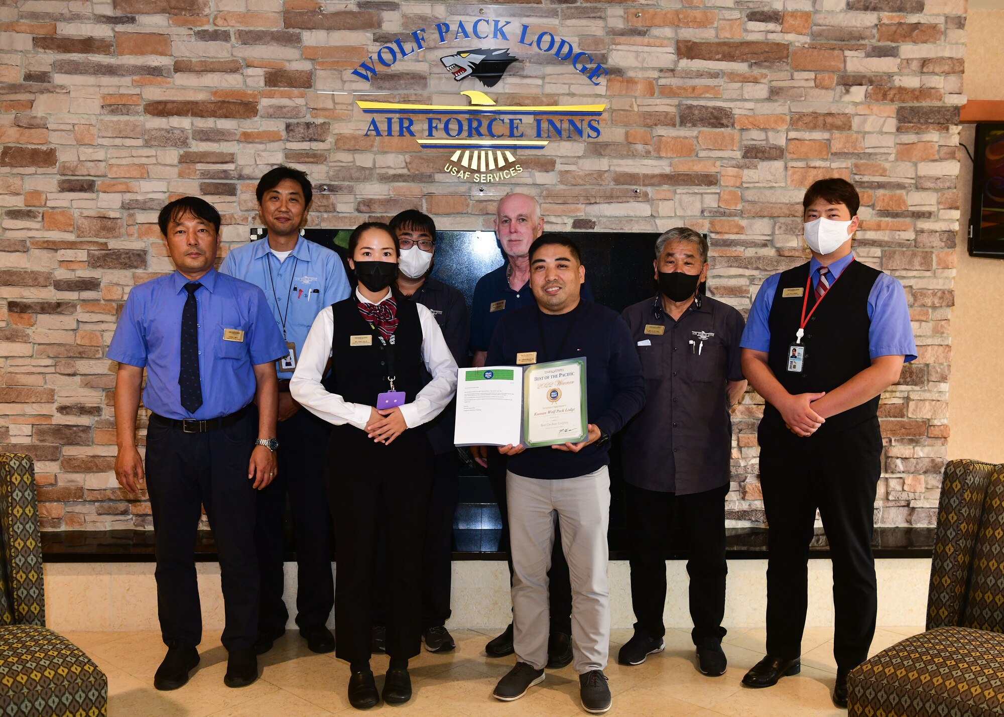 Military members and civilians pose for an award presentation.