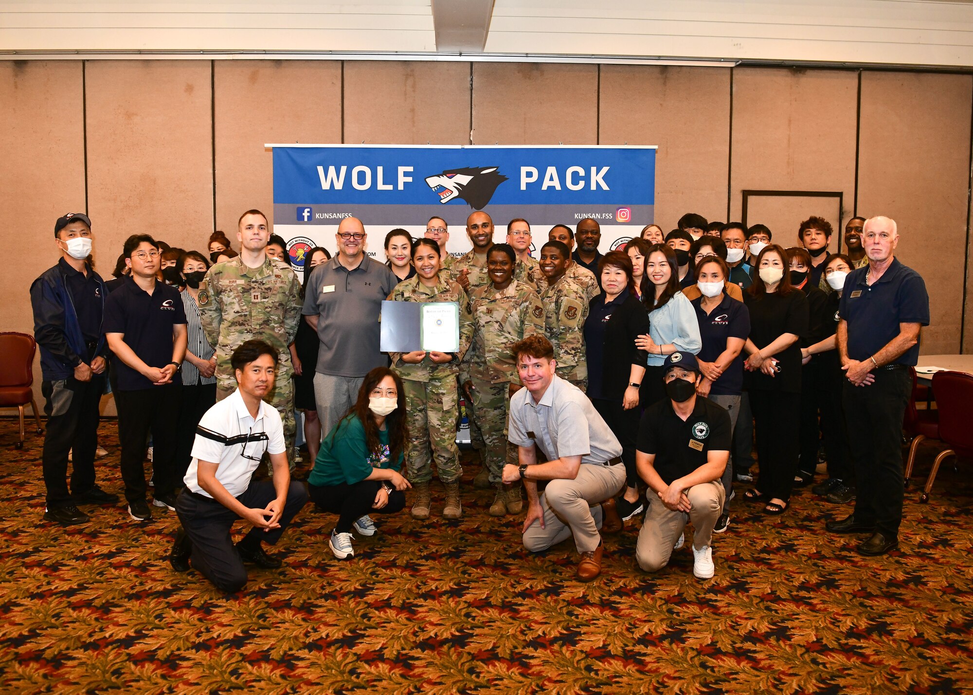 Military members and civilians pose for an award presentation.