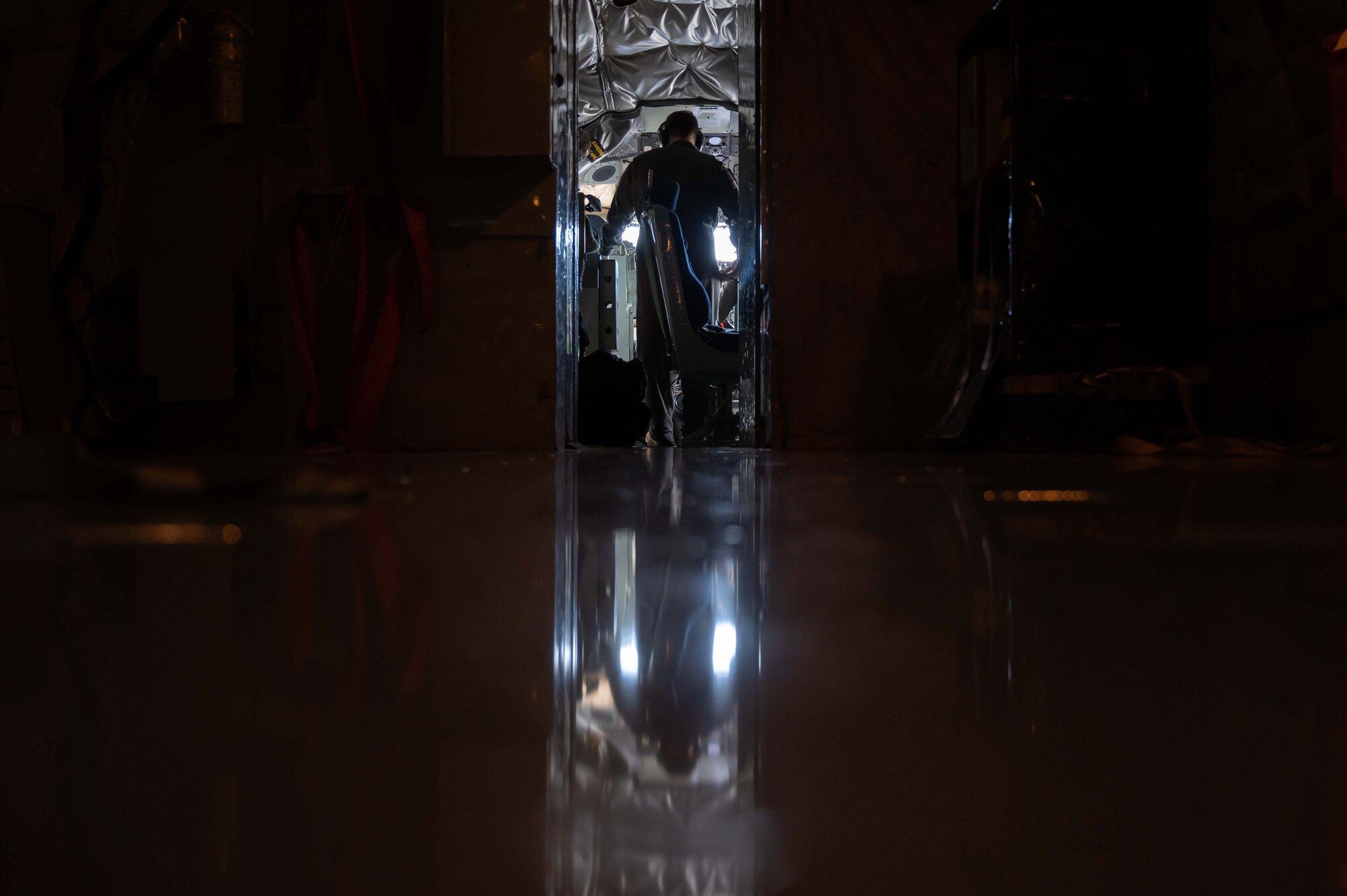 Airman stands in the cockpit of an aircraft