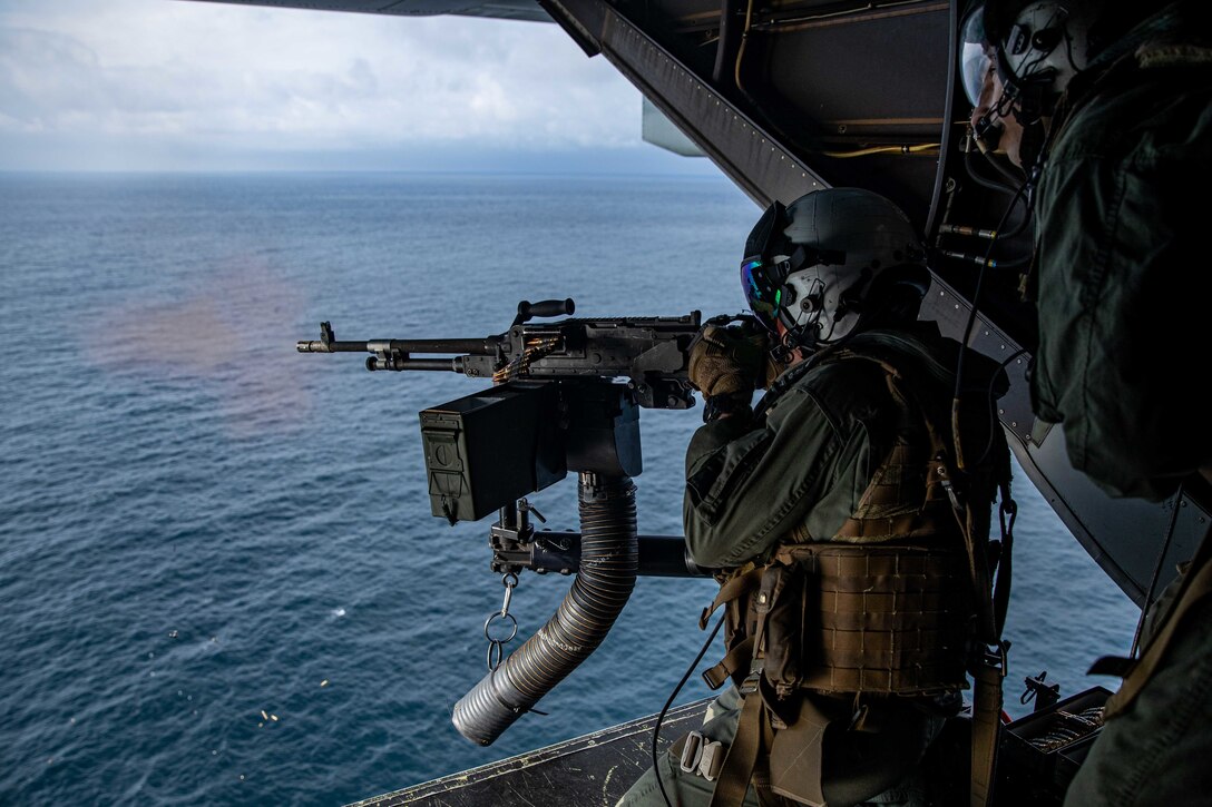 U.S. Marine Corps 1st Lt. Sam Abernathy, an intelligence officer with Aviation Combat Element, 22nd Marine Expeditionary Unit, fires an M240-B machine gun from the back of an MV-22 Osprey during a live-fire exercise over the Atlantic Ocean, June 23, 2022.