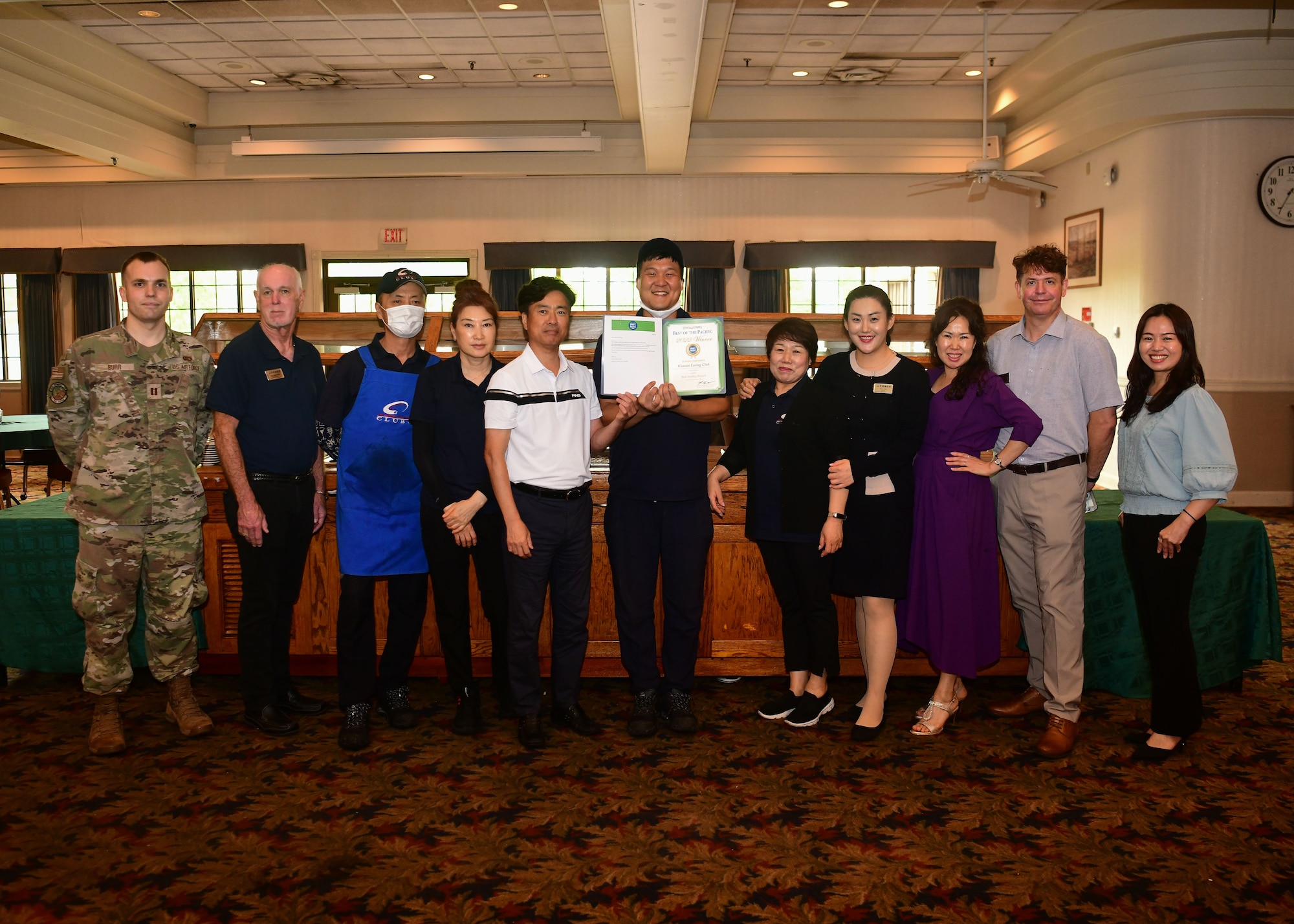 Military members and civilians pose for an award presentation.