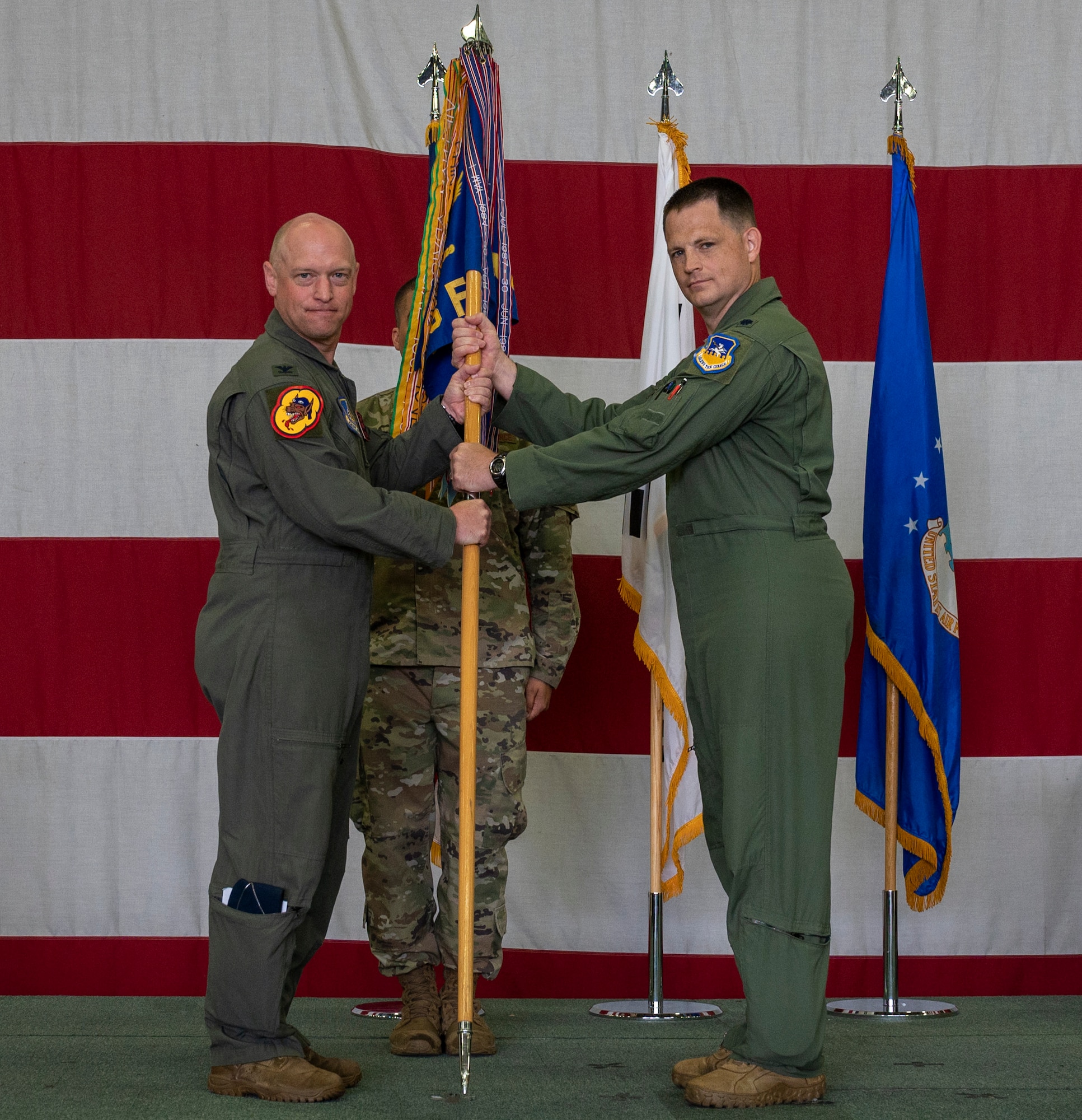 Col. Mathew Gaetke, 51st Operations Group commander, left, passes the squadron guidon to Lt. Col. Cory Farrer, 36th Fighter Squadron incoming commander, as a symbol of his taking command of the 36th FS at Osan Air Base, Republic of Korea, June 30, 2022.