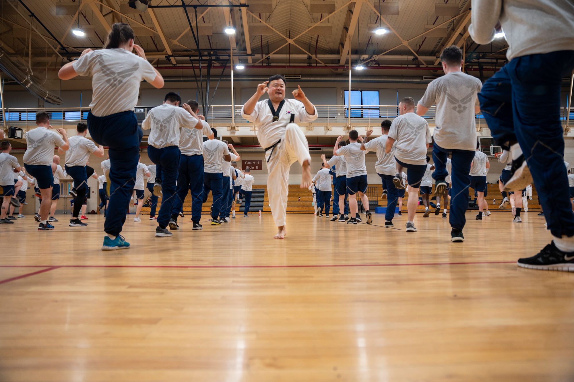 Grandmaster Huisong Mun, Taekwondo Promotion Foundation, leads Airmen from the 51st Mission Support Group on proper kicking strikes at Osan Air Base, Republic of Korea, June 30, 2022.