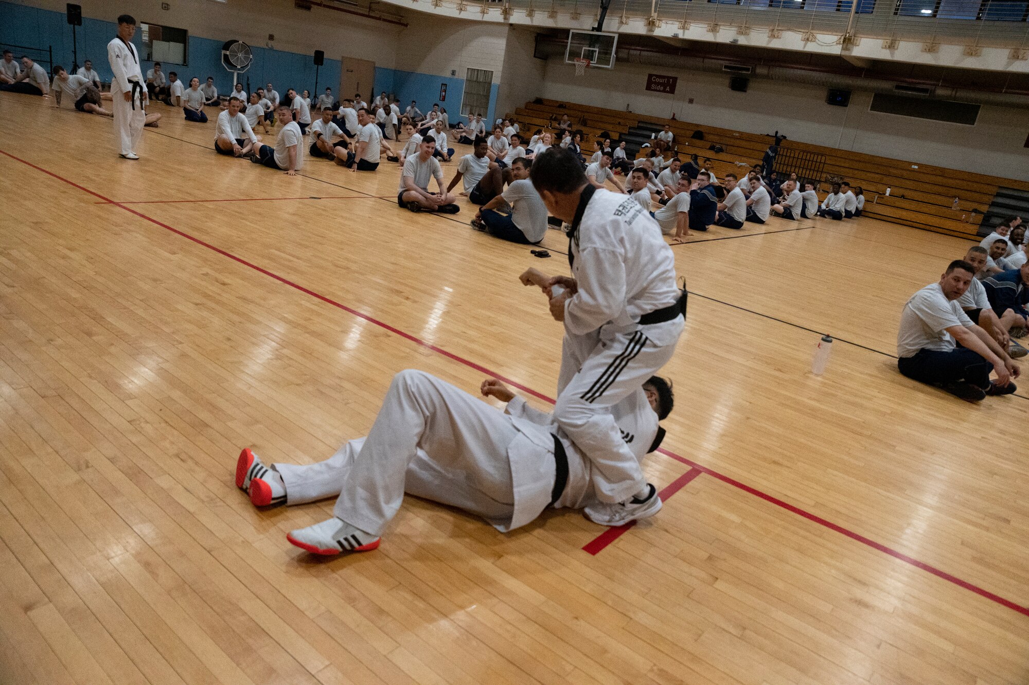Grandmaster Munok Kim and Master Doyoung Jang, Taekwondo Promotion Foundation, demonstrate proper takedown techniques during a 51st Mission Support Group physical training session at Osan Air Base, Republic of Korea, June 30, 2022.