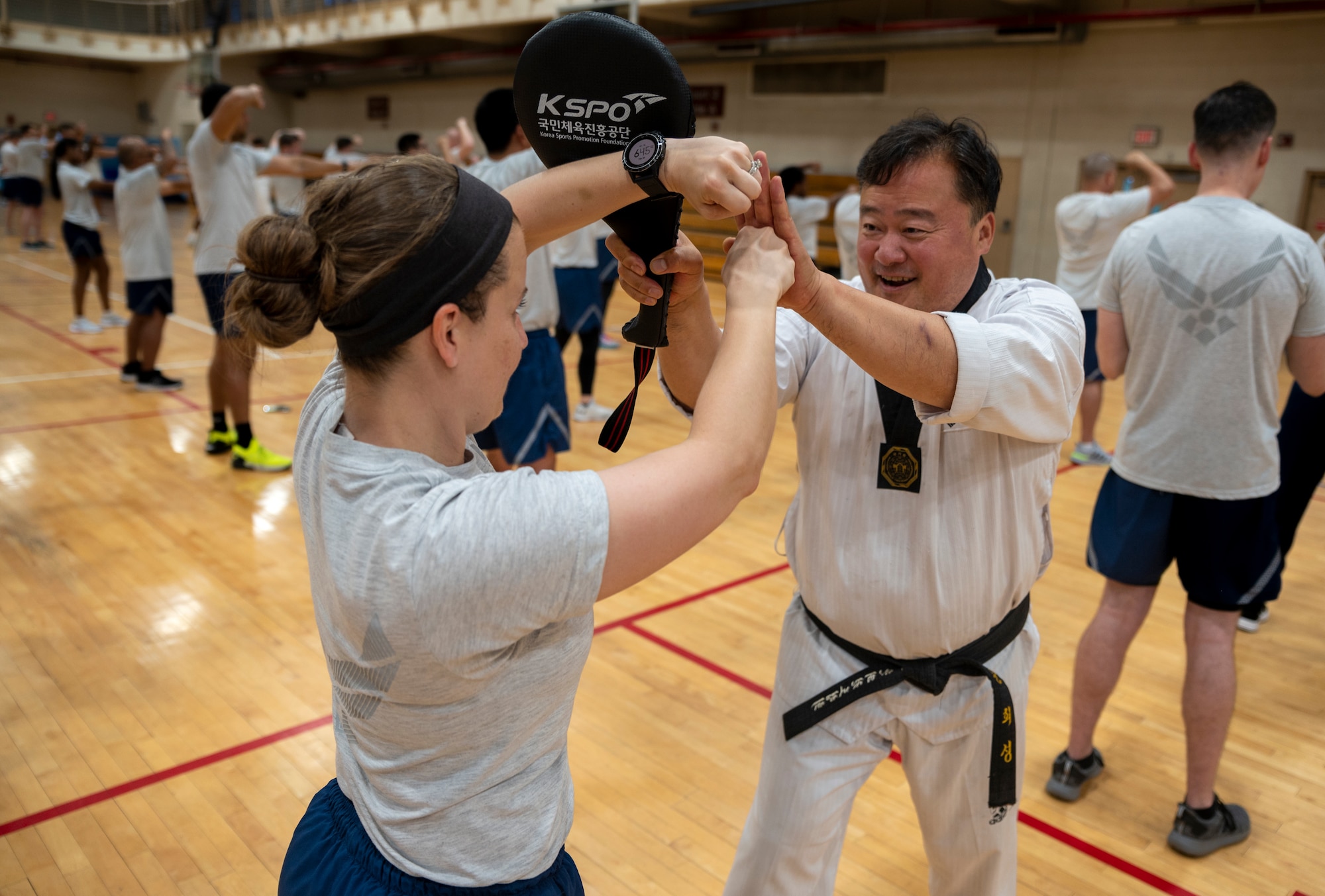 Grandmaster Huisong Mun, Taekwondo Promotion Foundation, teaches Airmen from the 51st Mission Support Group, proper taekwondo take-down techniques during an MSG physical training session at Osan Air Base, Republic of Korea, June 30, 2022.