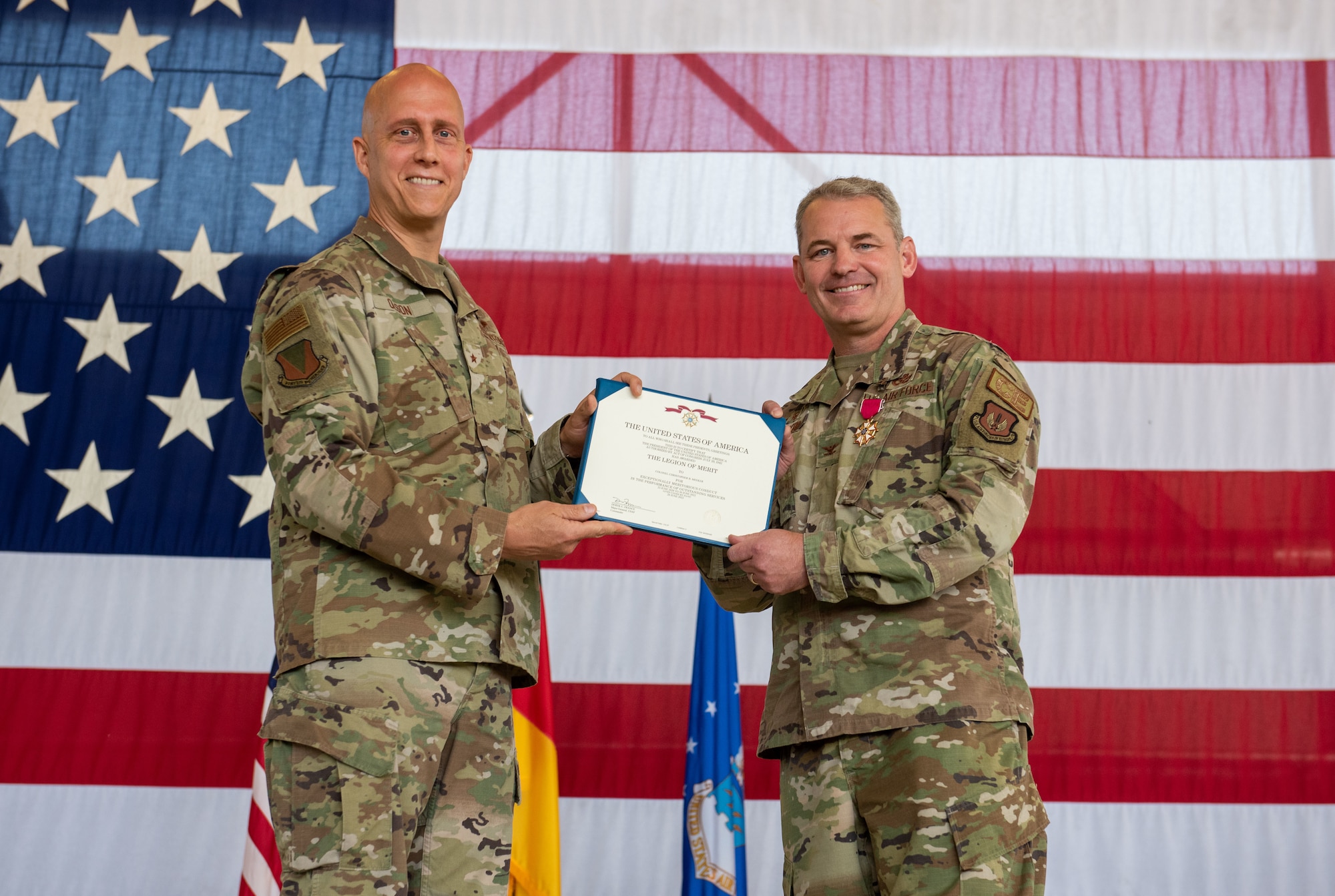 U.S. Air Force Brig. Gen. Joshua M. Olson, 86th Airlift Wing commander, left, presents Col. Christopher B. Meeker, 86th Civil Engineer Group outgoing commander, with a Legion of Merit certificate during the 86 CEG change of command ceremony at Ramstein Air Base, Germany