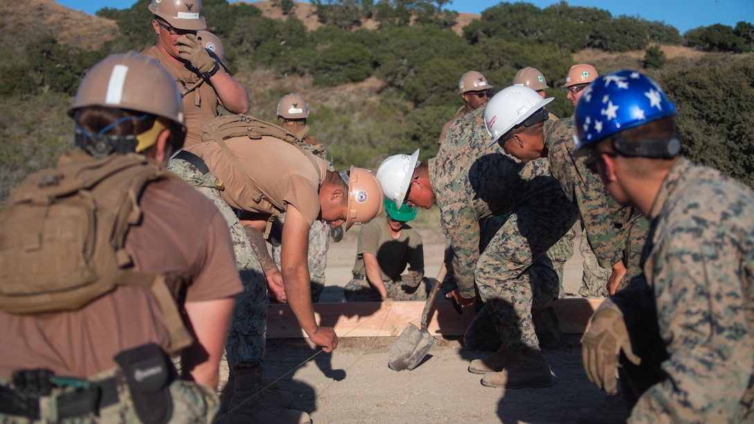 U.S. Marines with Marine Wing Support Squadron 372, Marine Air Control Group 38, 3rd Marine Aircraft Wing, and U.S. Navy Sailors with Naval Mobile Construction Battalion 5 lay concrete to expand a vertical take-off and landing pad as part of Exercise Turning Point at Vandenberg Space Force Base, California, June 5, 2022. Turning Point is a combat operation readiness exercise designed to support and enable fleet maneuver and logistics, enhance joint interoperability, and increase the combat readiness of multiple services. 3rd Marine Aircraft Wing’s warfighting readiness directly enables aviation superiority in support of the Marine Air-Ground Task Force and joint operations and deters potential adversaries.