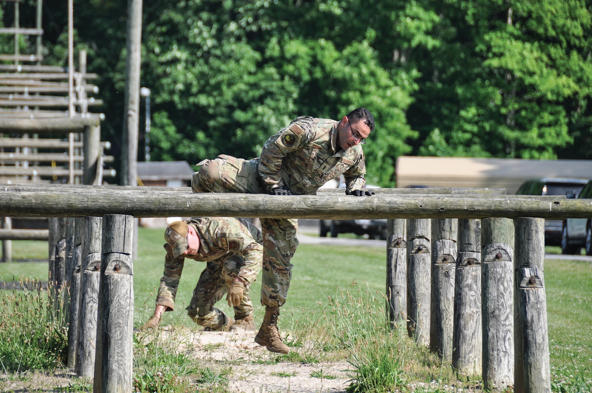 445th Security Forces Squadron Airmen maneuver over a log on an Army training course at Camp Dawson, West Virginia. The defenders tackled the nine-part obstacle course on June 8 as four-person fire teams, with the quickest team completing all obstacles in just under 10 minutes.