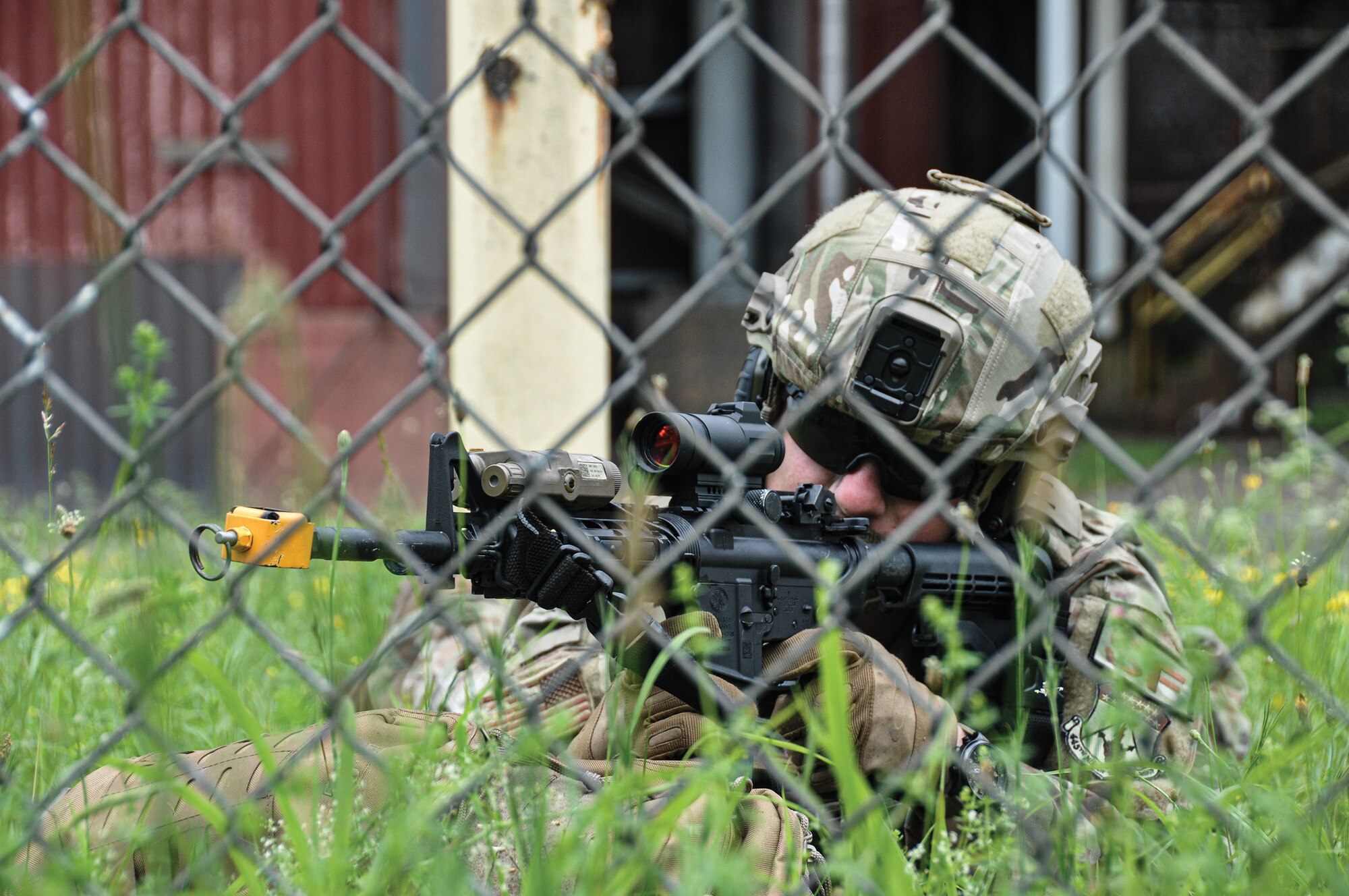 Staff Sgt. Blake Bethel, 445th Security Forces Squadron fire team leader, returns fire with an M4 carbine to members of a fictional insurgency group attacking a decommissioned power plant in rural West Virginia as part of a training event. The squadron conducted the all-day field training exercise at the plant on June 9, 2022, using blank rounds of ammunition and blank-firing attachments on their firearms to force negative pressure back into the barrel, chambering the next round of ammunition and providing a realistic effect.