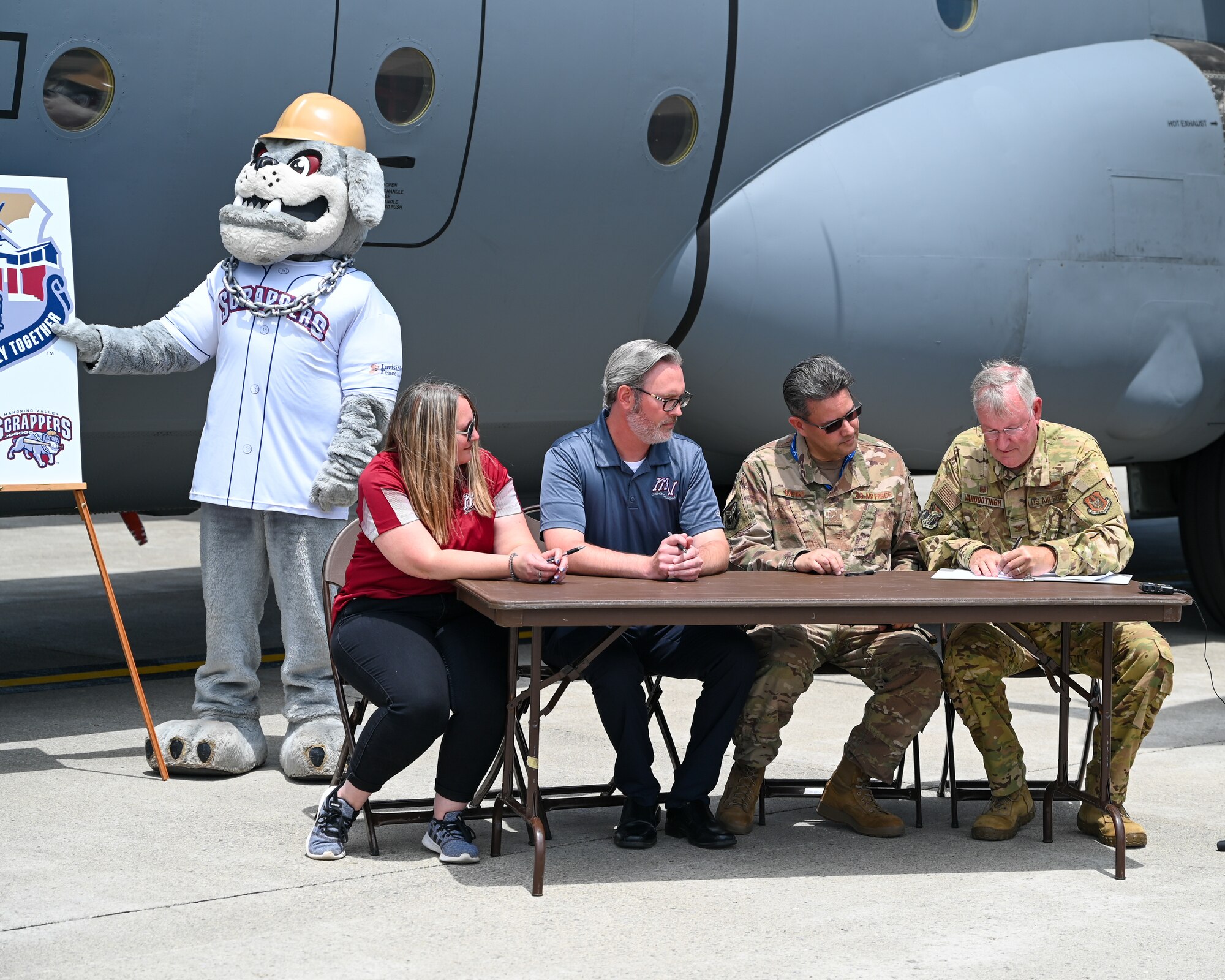 Heather Sahli, assistant general manager of marketing for the Mahoning Valley Scrappers baseball team, Jordan Taylor, vice president of HWS Baseball, Senior Master Sgt. Bob Barko Jr., 910th Airlift Wing public affairs superintendent, and Col. Jeff Van Dootingh, 910th AW commander, sign a partnership agreement for the "Operation Fly Together" campaign, June 29, 2022, at Youngstown Air Reserve Station, Ohio.