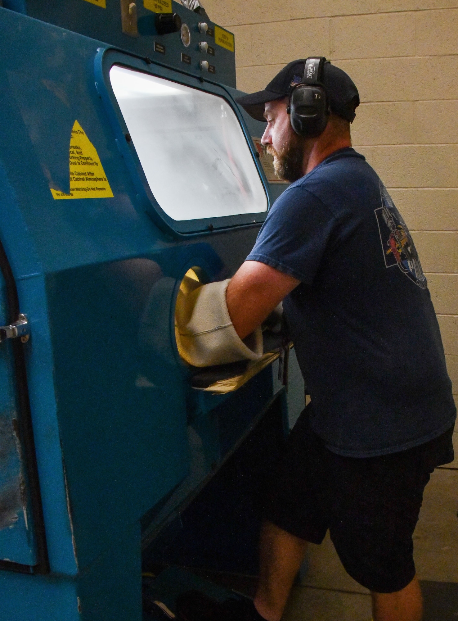 Anthony Micare, 97th Maintenance Squadron aircraft painter, strips the paint from a KC-46 Pegasus wheel at Altus Air Force Base, Oklahoma, June 24, 2022. The paint is sandblasted with a machine called a hopper. (U.S. Air Force photo by Airman 1st Class Miyah Gray)