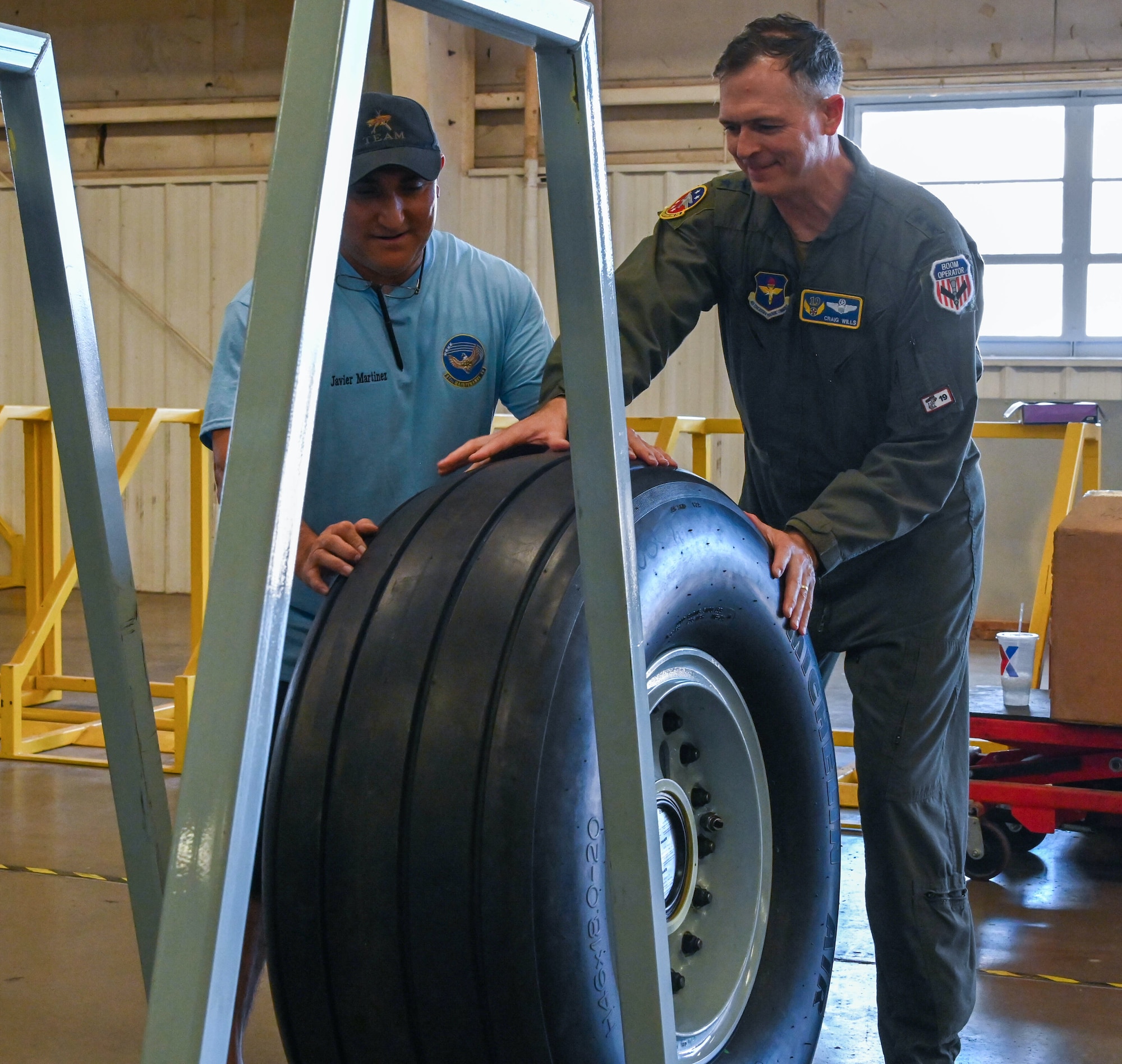 U.S. Air Force Maj. Gen. Craig D. Wills, 19th Air Force commander, rolls out the first in-shop assembled KC-46 Pegasus wheel at Altus Air Force Base, Oklahoma, June 23, 2022. Members of the 97th Maintenance Squadron demonstrated the new process of assembling KC-46 tires to Wills at a recent visit. (U.S. Air Force photo by Senior Airman Kayla Christenson)
