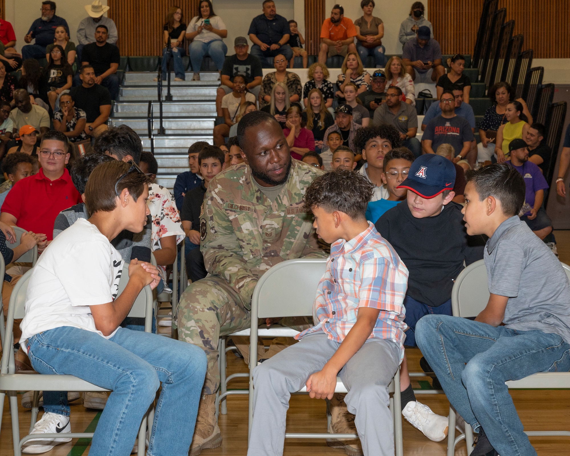 A photo of an Airman talking to children