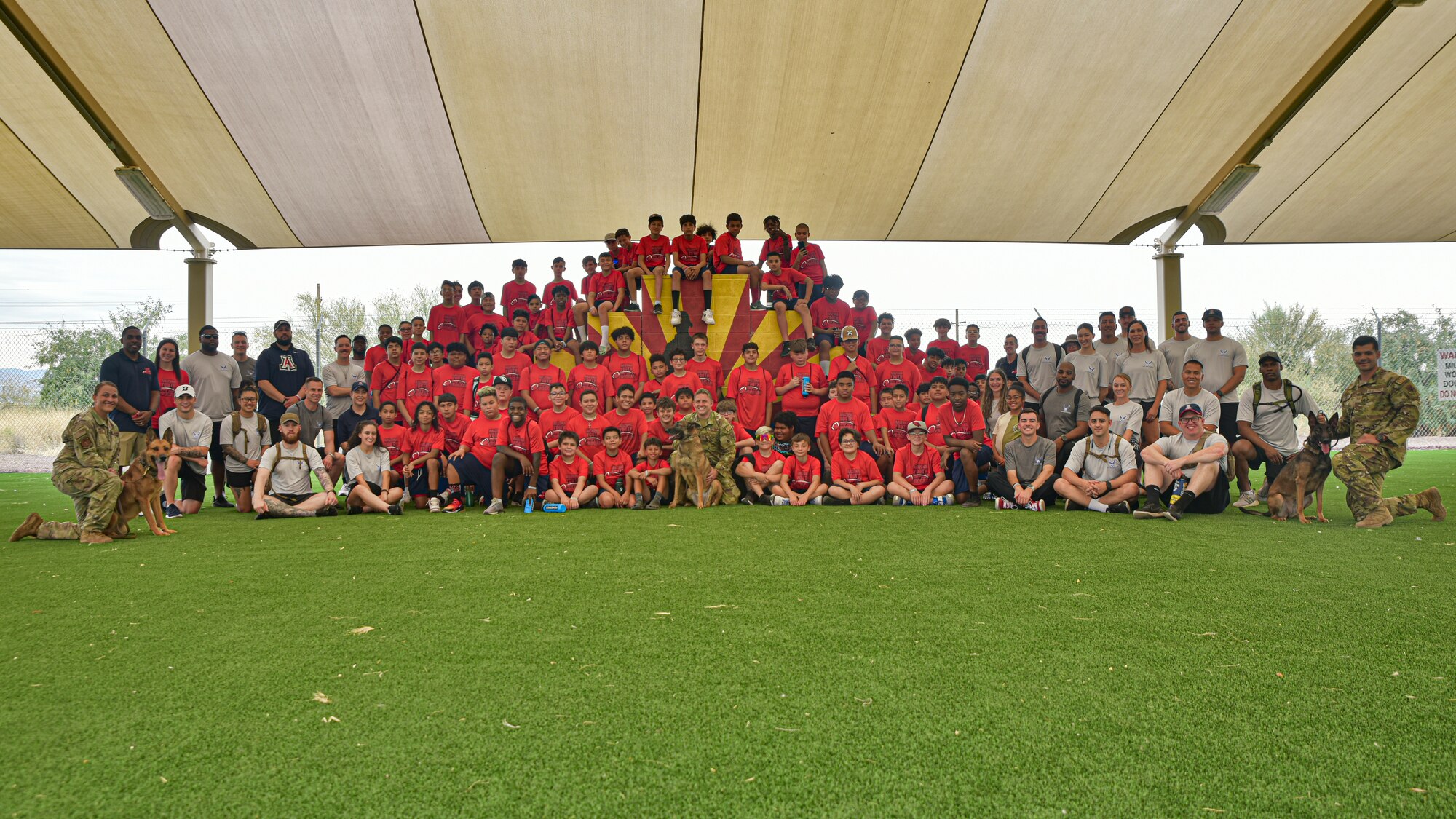 A group photo of Airmen, children and military working dogs