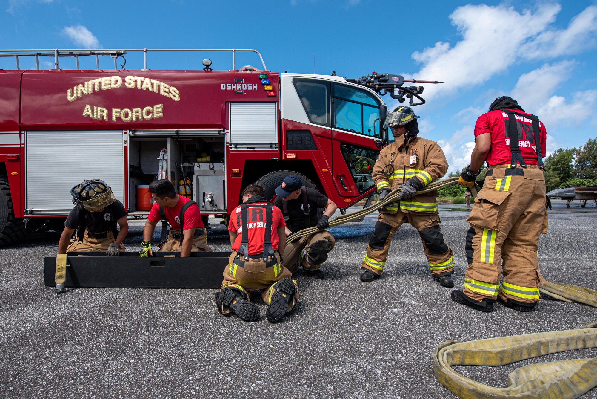 Firefighters prepare a fire hose.
