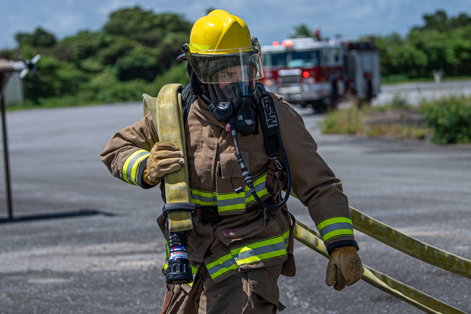 A firefighter carries a hose.