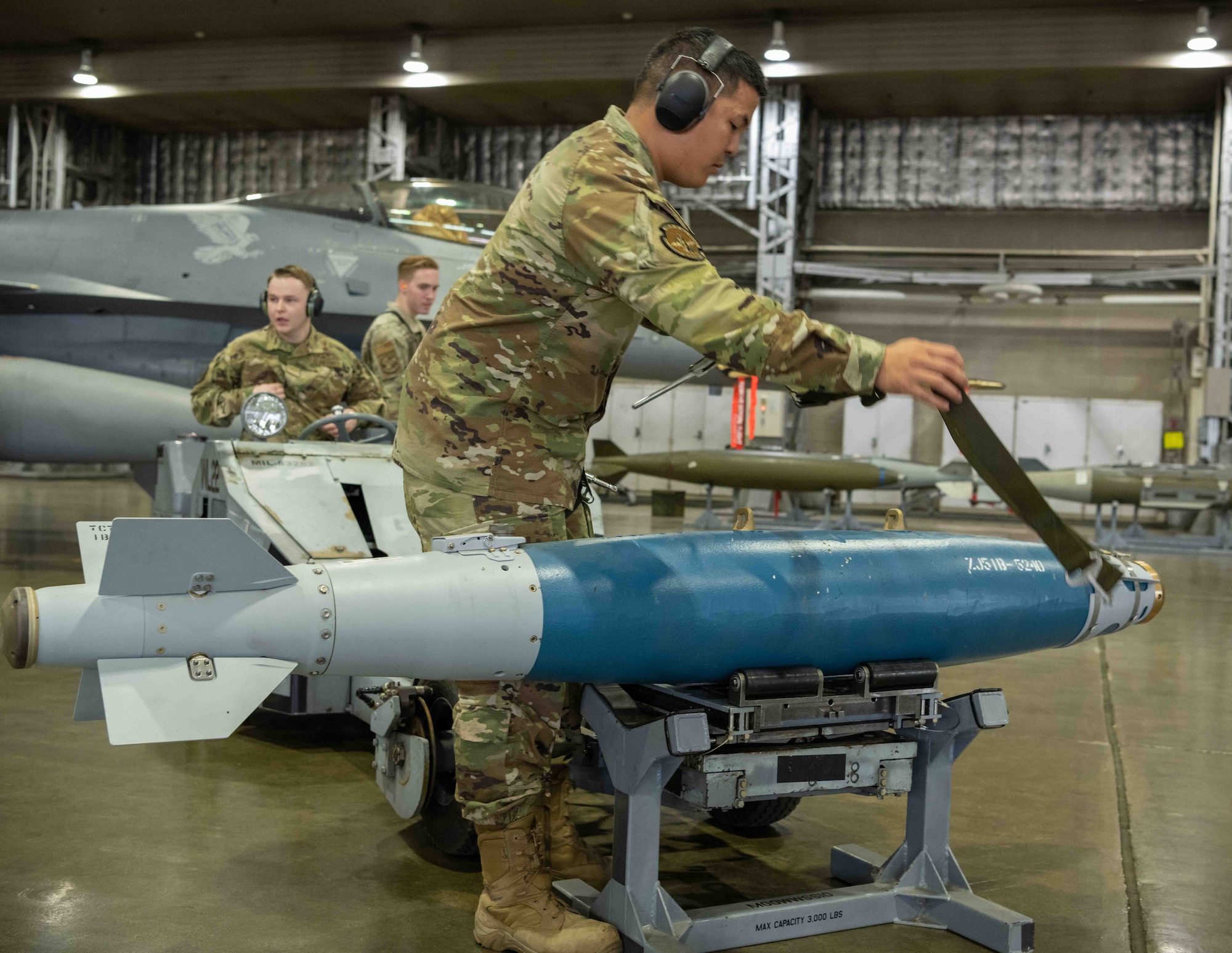 U.S. Air Force Staff Sgt. Anferne Phrachansiri, 14th Aircraft Maintenance Unit weapons load team chief, secures a training GBU-31 guided bomb, before loading it onto an F-16 Fighting Falcon during the second quarter load crew competition at Misawa Air Base, Japan, July 1, 2022.