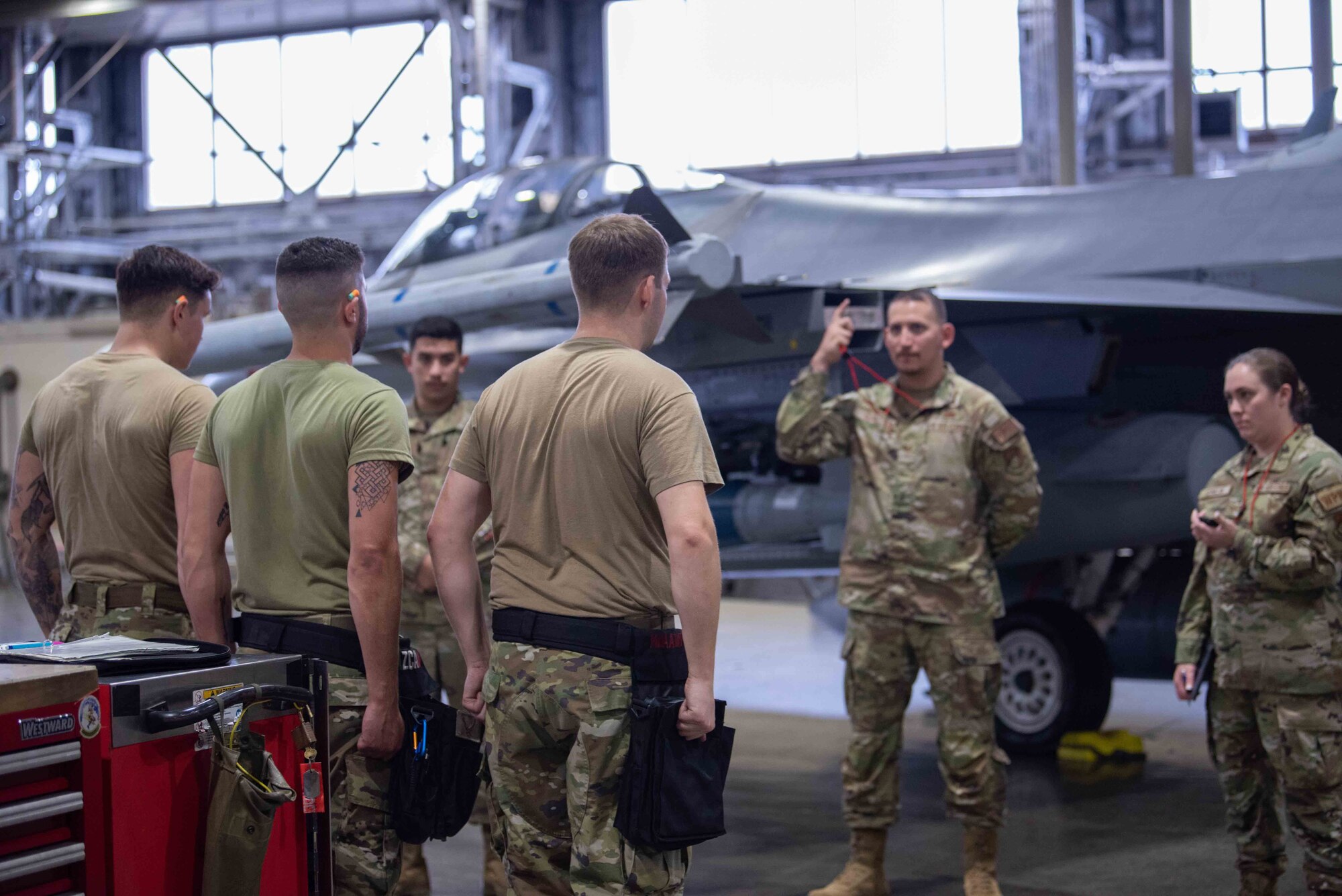 U.S. Air Force Airmen assigned to the 13th Aircraft Maintenance Unit stand at attention to notify their completion to the judges during the second quarter load crew competition at Misawa Air Base, Japan, July 1, 2022.