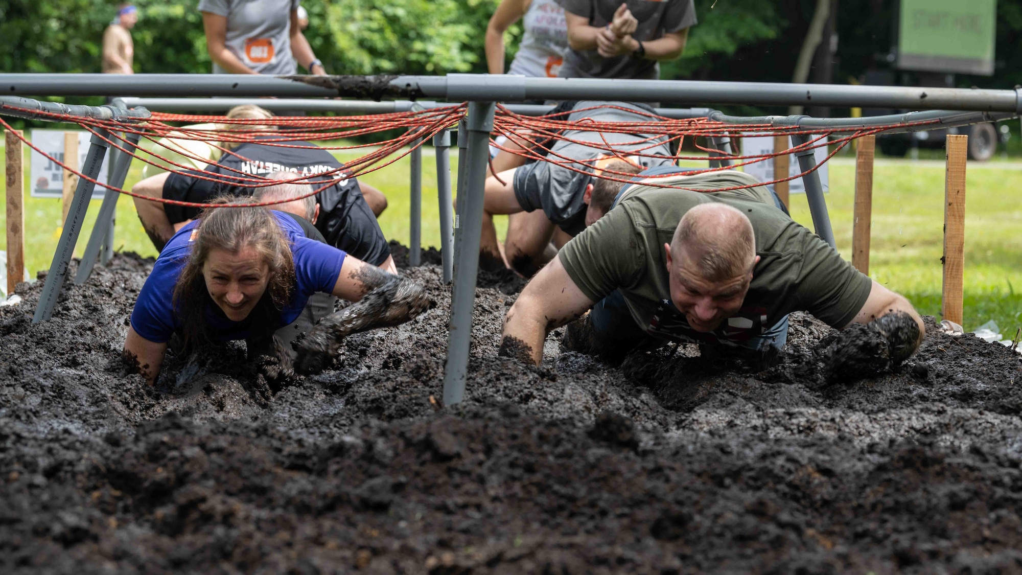 Participants crawl through the mud during the annual Misawa Mudder at Misawa Air Base, Japan, July 2, 2022.