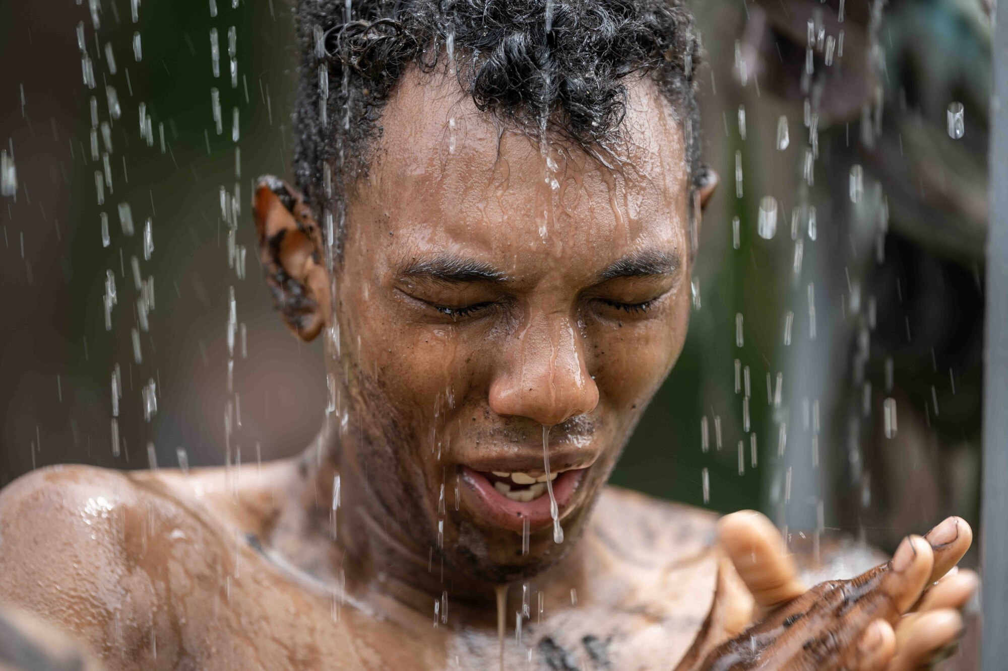 A participant washes off the mud after completing the annual Misawa Mudder at Misawa Air Base, Japan, July 2, 2022.