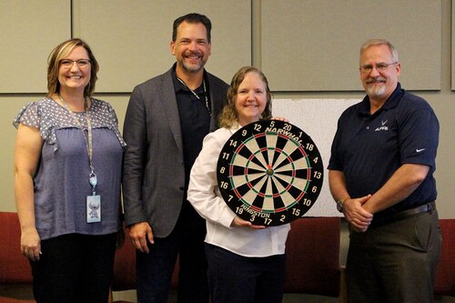 Air Force Research Laboratory Digital Transformation Director Dr. Michael Gregg, far right, and AFRL Digital War Room members, from left, Andrea Mahaffey, Dr. James Sumpter and Dr. Pamela Kobryn, with the dart board used to officially release the Digital Accelerator for Research Transformation effort, DART 1.0, to the workforce at Wright-Patterson Air Force Base, Ohio, June 30, 2022. DART is an online library with new products, capabilities and solutions offered to the workforce on a quarterly basis in support of the lab’s digital transformation efforts. (U.S. Air Force photo / Kati Cospy)