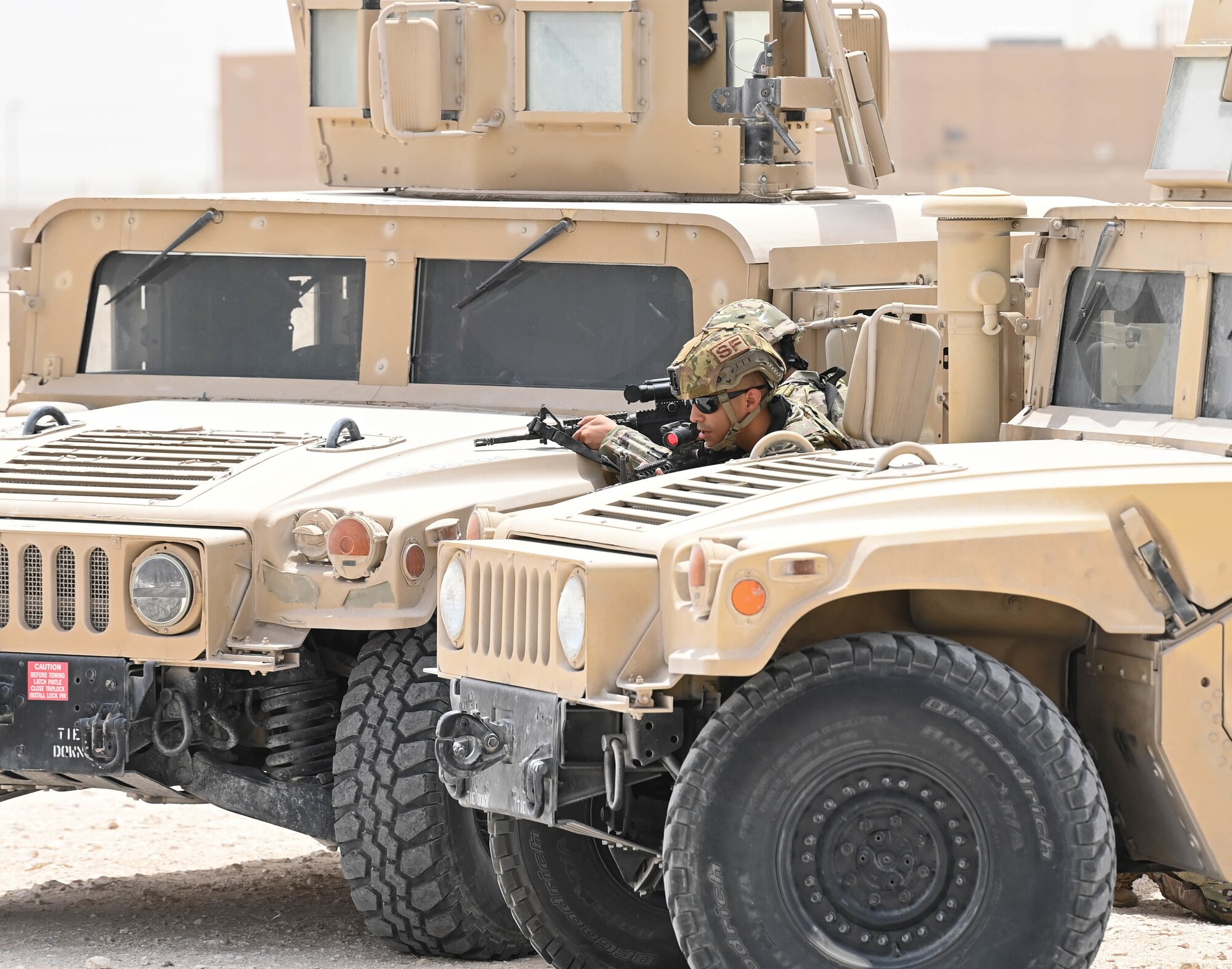 379th Expeditionary Security Forces Squadron defenders take cover behind Humvees during a fire and move demonstration July 1, 2022 at Al Udeid Air Base, Qatar. The Defenders showcased how to advance on a target while maintaining fire and communication. (U.S. Air National Guard photo by Tech. Sgt. Michael J. Kelly)