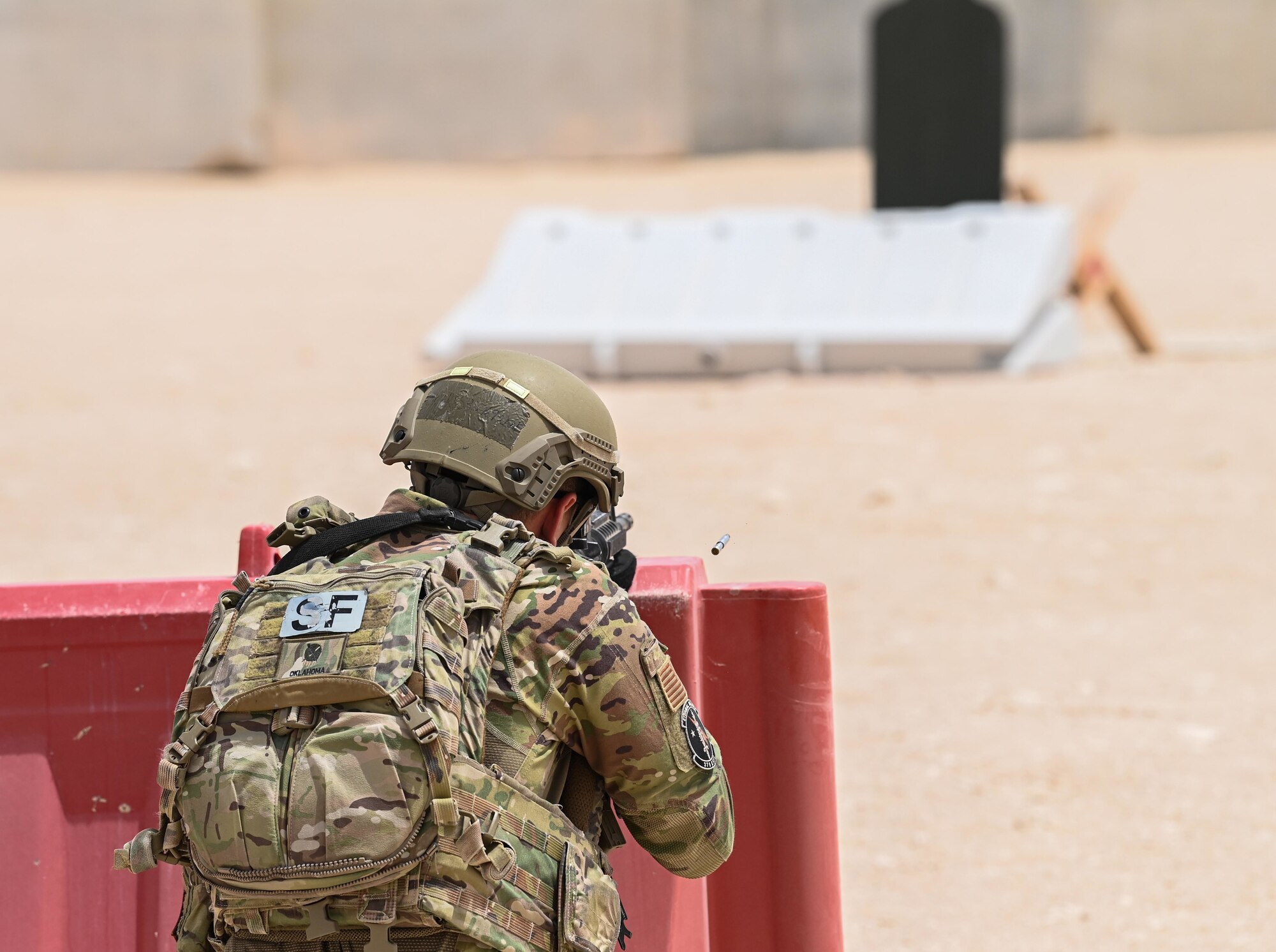 U.S. Air Force Tech. Sgt. Tristan Ressler, a 379th Expeditionary Security Forces Squadron defender, shoots an M-4 carbine during a shoot, move and communicate demonstration July 1, 2022 at Al Udeid Air Base, Qatar. The Defenders used non-lethal paint filled rounds to safely execute the training. (U.S. Air National Guard photo by Tech. Sgt. Michael J. Kelly)