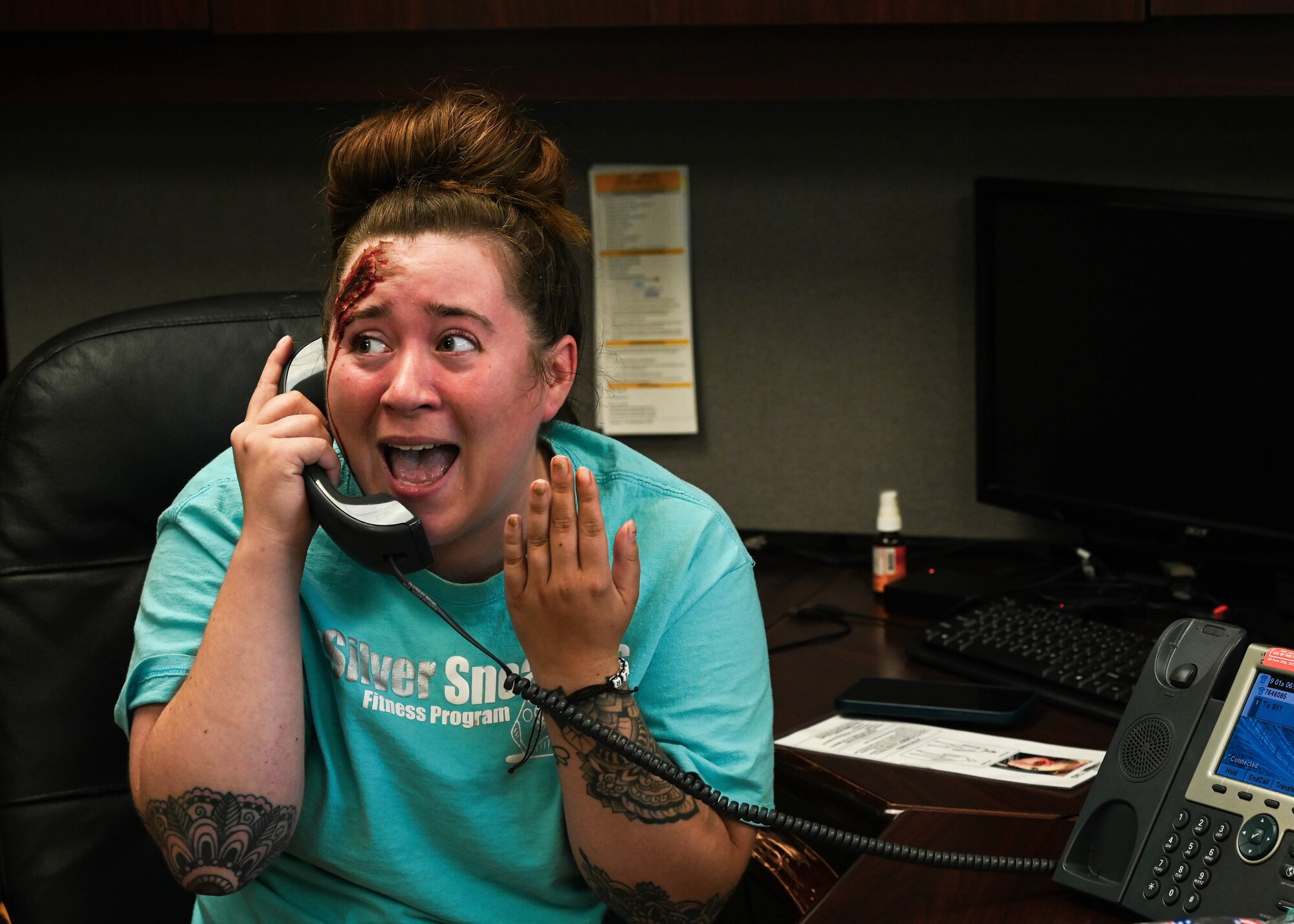 A U.S. Air Force Airman makes a call to emergency services during a base-wide active shooter exercise at Joint Base Langley-Eustis, Virginia, June 28, 2022.