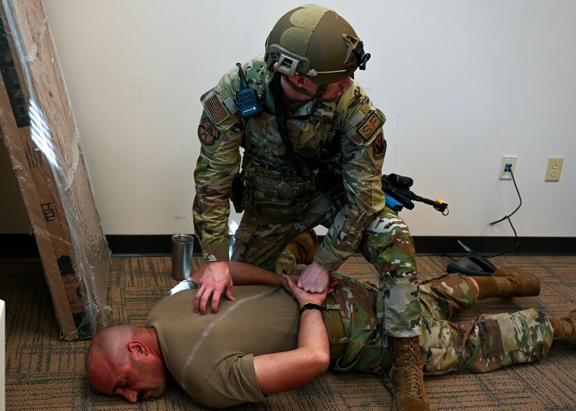 A member of the 633d Security Forces Squadron apprehends a simulated active shooter during an exercise at Joint Base Langley-Eustis, Virginia, June 28, 2022.