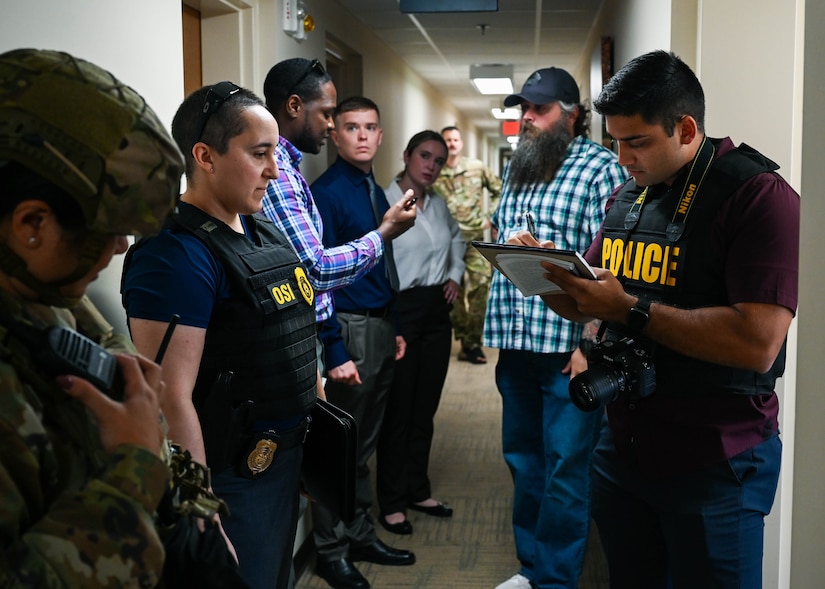 Special Agents from the Office of Special Investigations confer with a member of the 633d Security Forces Squadron during a base-wide active shooter exercise at Joint Base Langley-Eustis, Virginia, June 28, 2022.