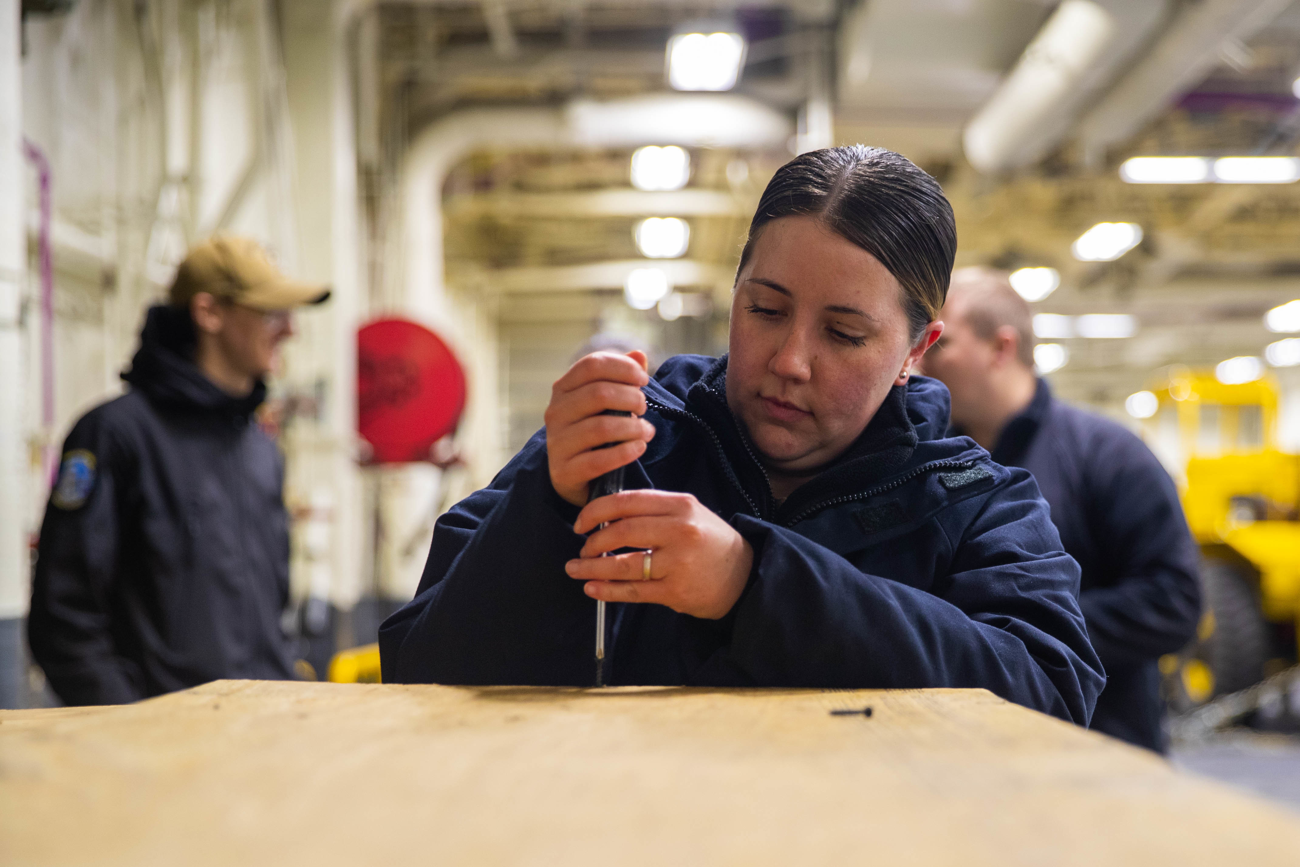 220514-N-CM110-1032 PACIFIC OCEAN (May 14, 2022) – Aerographer’s Mate 1st Class Ashley Mccown, from El Paso, Texas, unscrews the lid of a buoy crate in the vehicle stowage area aboard amphibious assault carrier USS Tripoli (LHA 7), May 14, 2022. Tripoli is underway conducting routine operations in U.S. 7th Fleet. (U.S. Navy photo by Mass Communication Specialist 3rd Class Maci Sternod