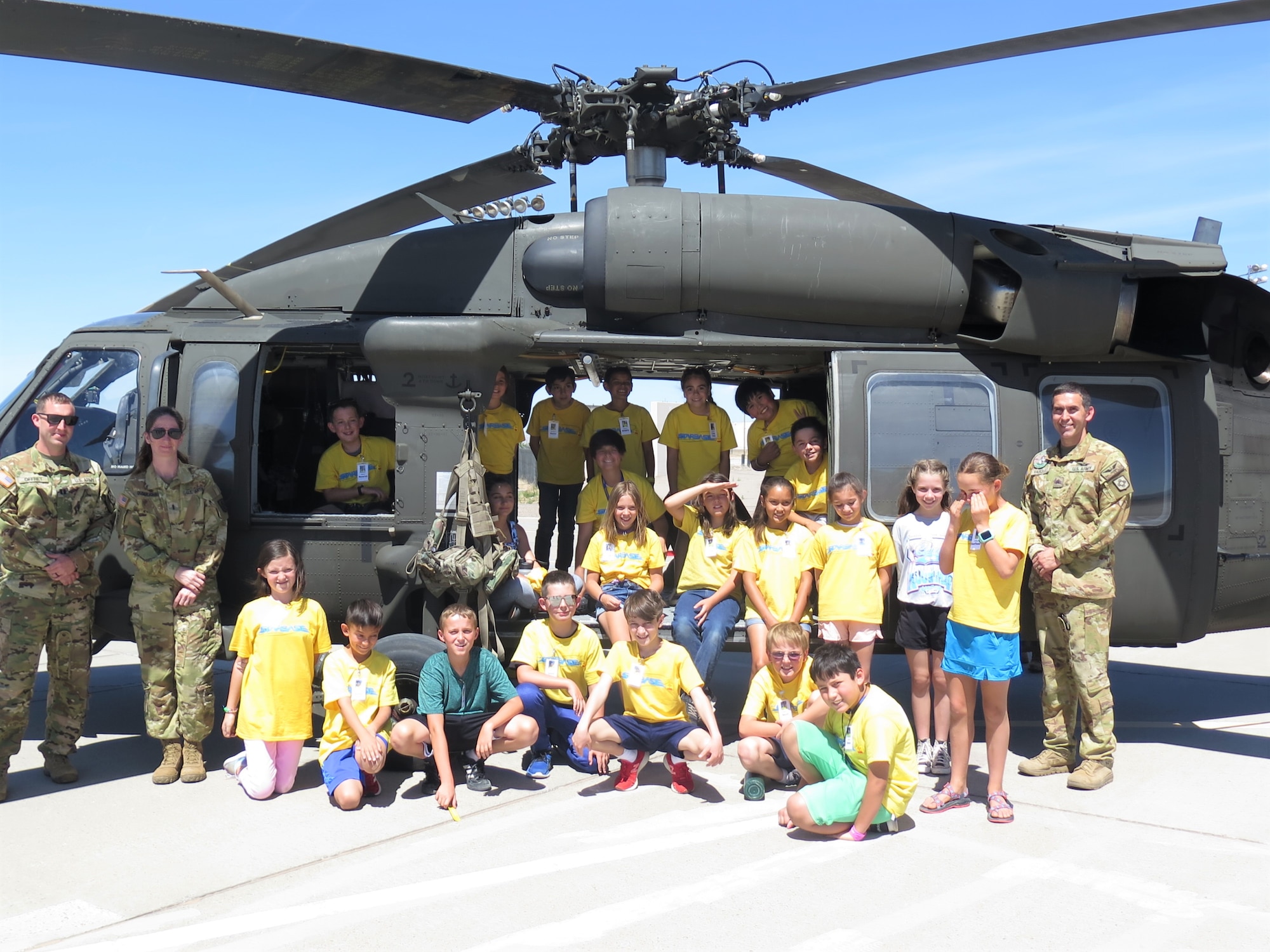 Members of the New Mexico Army National Guard, from left, Capt. Dustin Offret, Chief Warrant Officer 3 Anita Guderjohn, Sgt. Benjamin Vasquez, and students stand in front of an Army UH-60 Black Hawk helicopter during the Air Force Research Laboratory's DOD STARBASE STEM Camp at Kirtland Air Force Base, New Mexico, June 14, 2022.