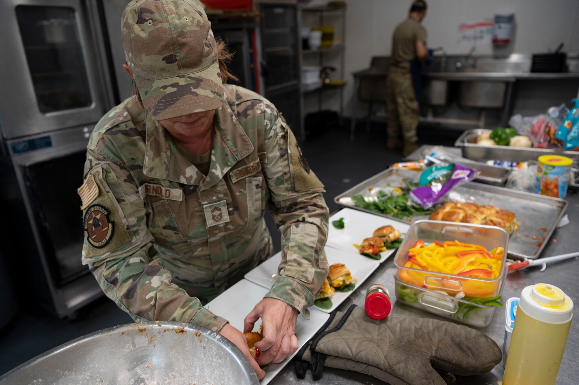 U.S. Air Force Chief Master Sgt. Marty Arnold, a 1st Special Operations Force Support Squadron culinary specialist, plates the meal her team has prepared during the 2022 Regional Chef Competition June 30, 2022, at Eglin Air Force Base, Florida.
