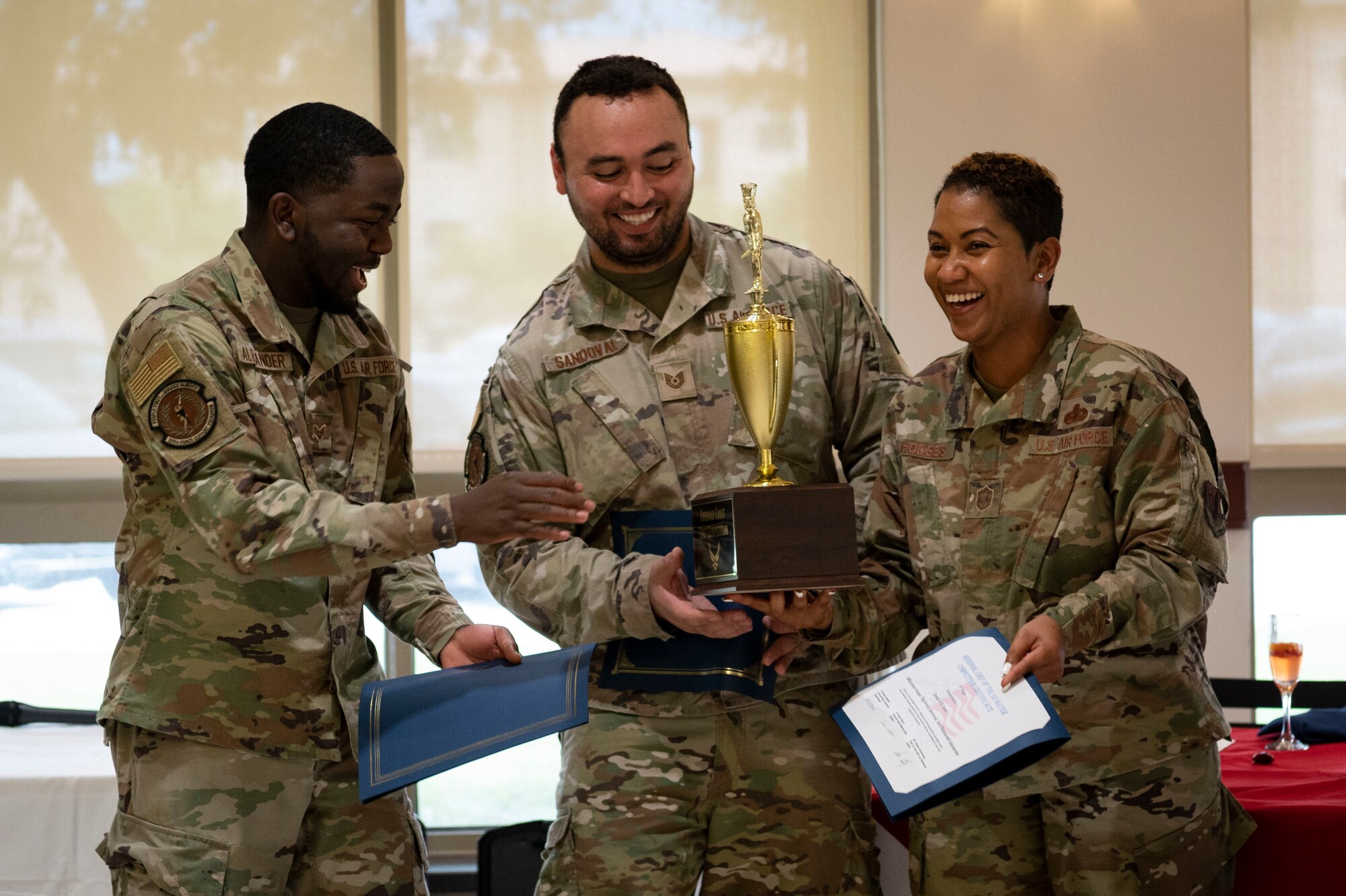 U.S. Air Force Senior Airman Roosevelt Alexander, left, U.S. Air Force Tech. Sgt. Arnold Sandoval, middle, and U.S. Air Force Senior Master Sgt. Ayana Hodges, right, 325th Force Support Squadron culinary specialists, accept their trophy for coming in first place at the 2022 Regional Chef Competition June 30, 2022, at Eglin Air Force Base, Florida.