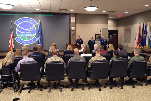 Photo of U.S. Airmen speaking at a podium to a group of seated guests