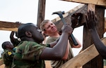 Members of the Rwanda Defense Force's Engineer Brigade work with Soldiers from the Nebraska Army National Guard's 623rd Engineer Company to build a guard tower, March 16, 2022, in Gako, Rwanda.
