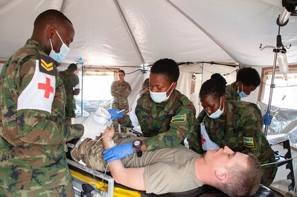 Medics from the Rwanda Defense Force's Medical Corps treat a simulated patient - a volunteer from the Nebraska Army National Guard - in a United Nations Level Two hospital during a medical/engineering exercise at Gako, Rwanda, in March 2022. The exercise enabled members of the Rwanda Defense Force and the Nebraska National Guard to work together through the Department of Defense National Guard Bureau State Partnership Program.