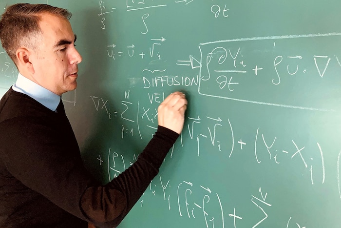 Photo of Dr. Javier Urzay writing on a chalkboard.