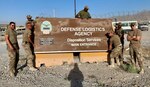 Disposition Services members next to DLA sign in Afghanistan