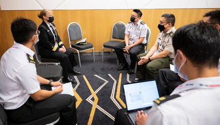 Rear Adm. Pamela Miller (rear-left), Command Surgeon for U.S. Indo-Pacific Command, speaks with delegates from Singapore during the second Military-Civilian Health Security Summit June 28, 2022, in Singapore. The summit, held June 27-28, focused on regional approaches to global health security through interagency cooperation with allies and partners.